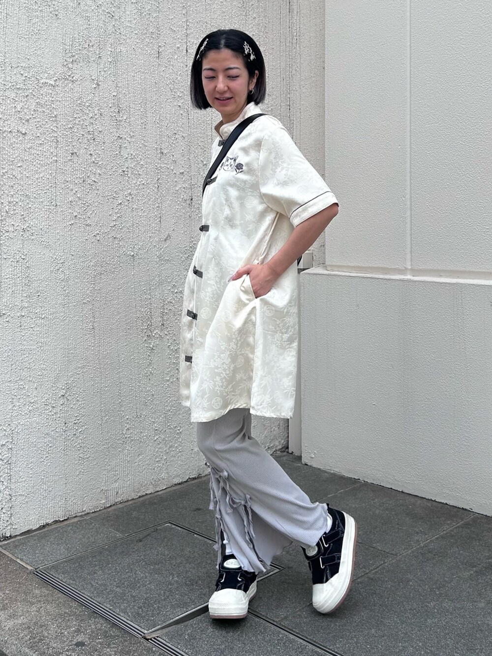 ブラック系のショルダーバッグ、グレー系のその他パンツ、ホワイト系のワンピースを着用したレディースの春コーディネートの5枚目の写真
