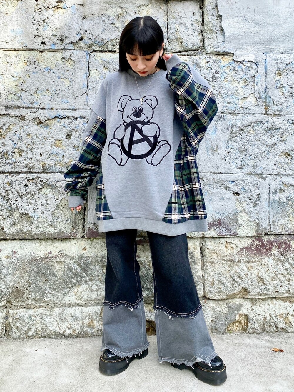 グレー系のスウェット、ブラック系のデニムパンツ、ブラック系のシューズを着用したレディースの冬コーディネートの2枚目の写真