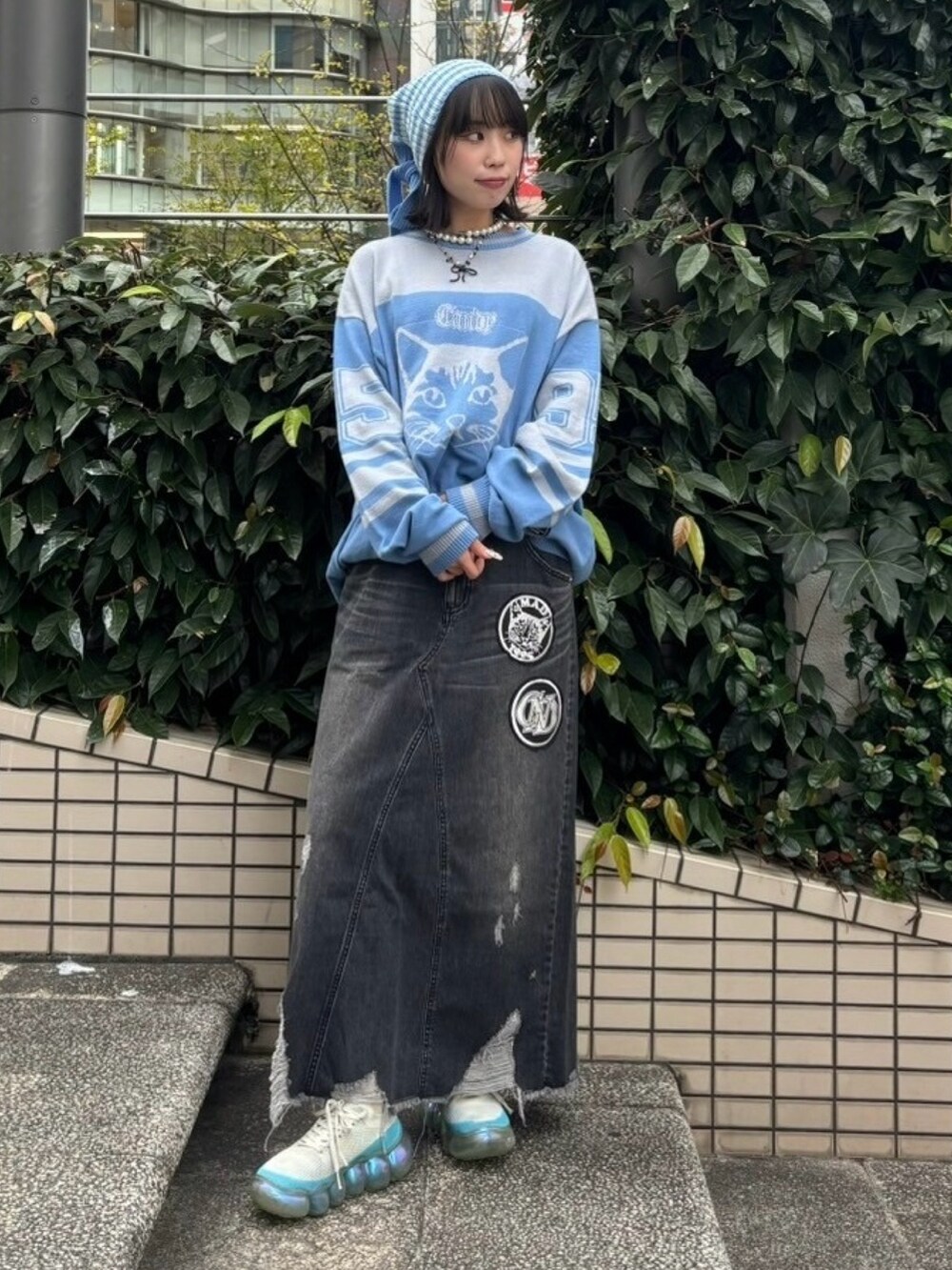 ブラック系のデニムスカート、ブルー系のニット/セーター、グリーン系のニットキャップ/ビーニーを着用したレディースの冬コーディネートの4枚目の写真