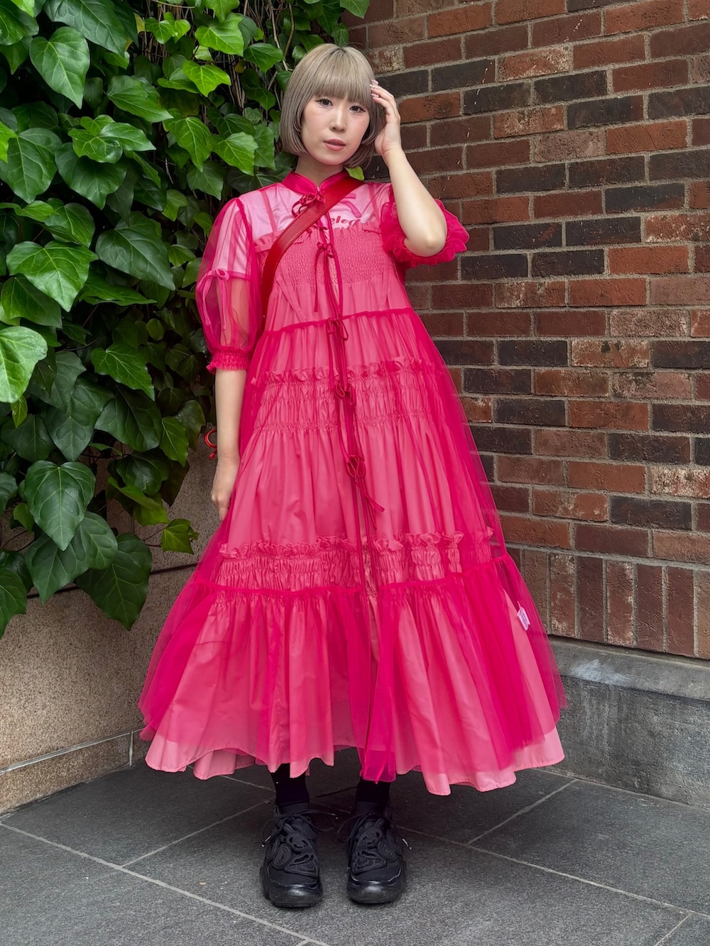 レッド系のショルダーバッグ、ピンク系のTシャツ/カットソー、ピンク系のワンピースを着用したレディースの夏コーディネートの2枚目の写真