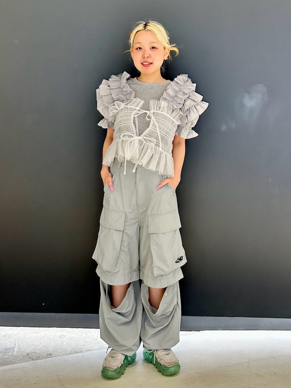 グレー系のカーゴパンツ、ホワイト系のキャミソール、グレー系のその他トップスを着用したレディースの春コーディネートの3枚目の写真