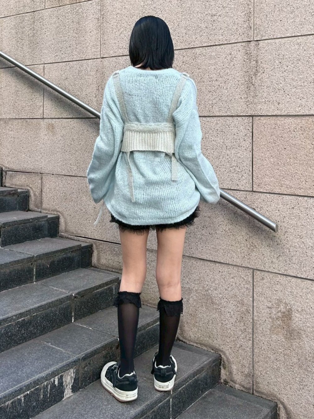 ブラック系のその他パンツ、ブルー系のニット/セーター、グレー系のその他トップスを着用したレディースの冬コーディネートの3枚目の写真