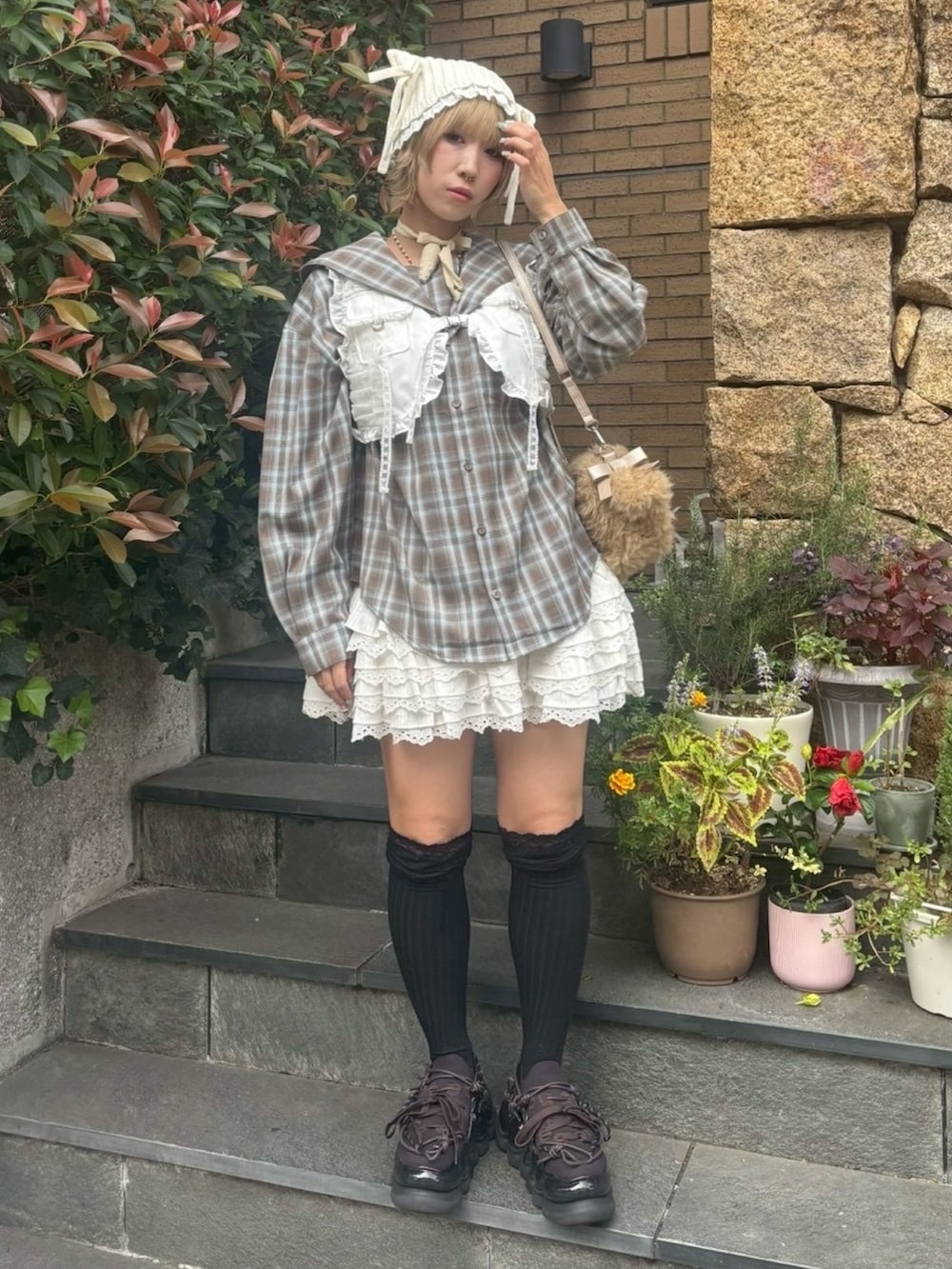 ブラウン系のシャツ/ブラウス、ホワイト系のベスト、ホワイト系のスカートを着用したレディースの秋コーディネートの2枚目の写真