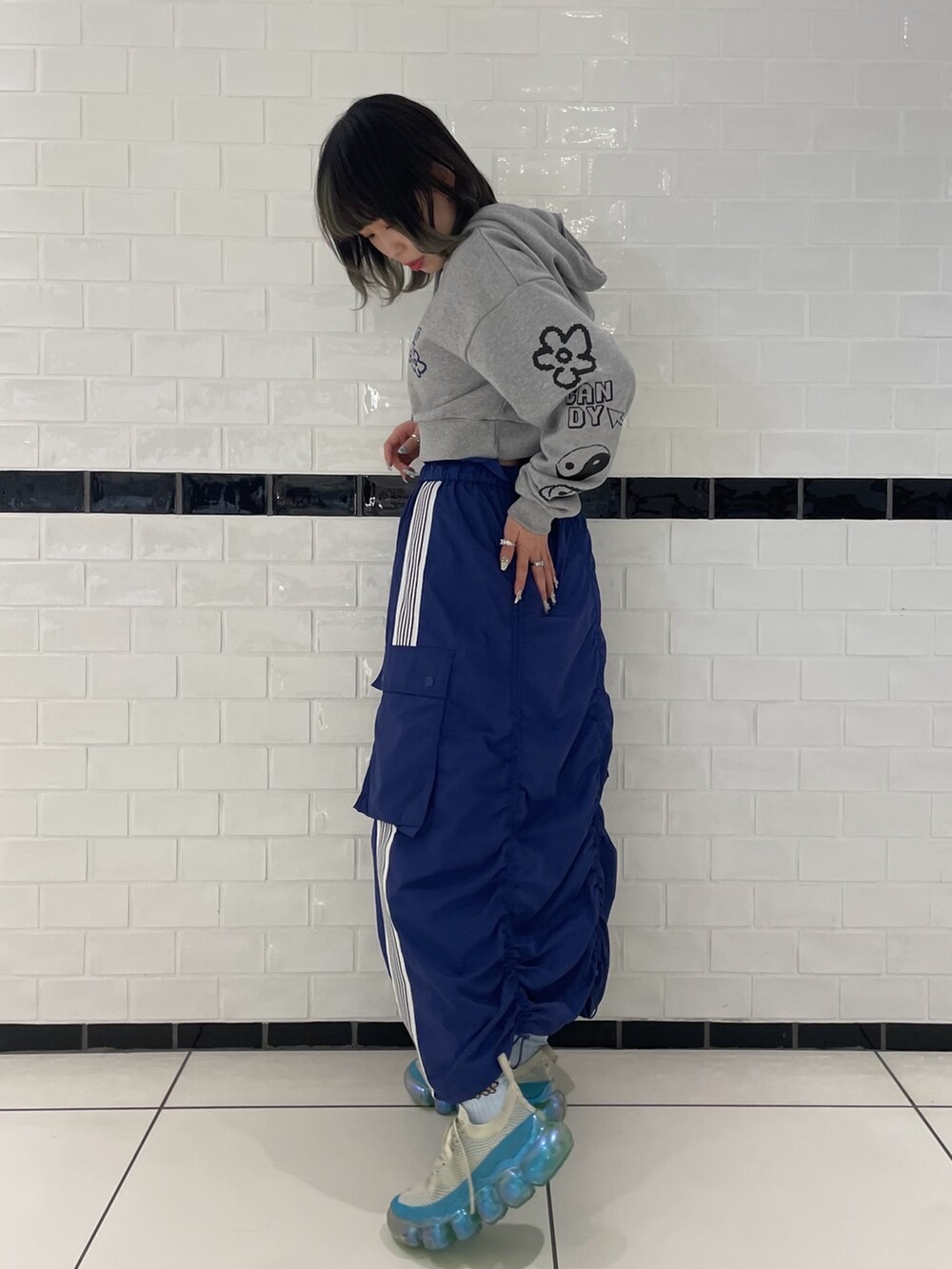 ブルー系のスカート、グレー系のパーカー、ブルー系のソックス/靴下を着用したレディースの冬コーディネートの2枚目の写真