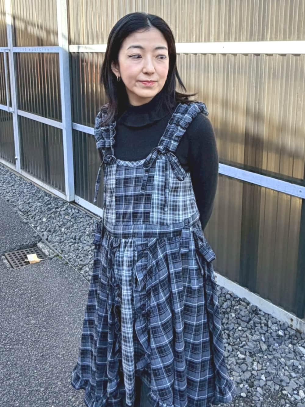 ブラック系のデニムパンツ、ブラック系のワンピース、ブラック系のニット/セーターを着用したレディースの冬コーディネートの4枚目の写真