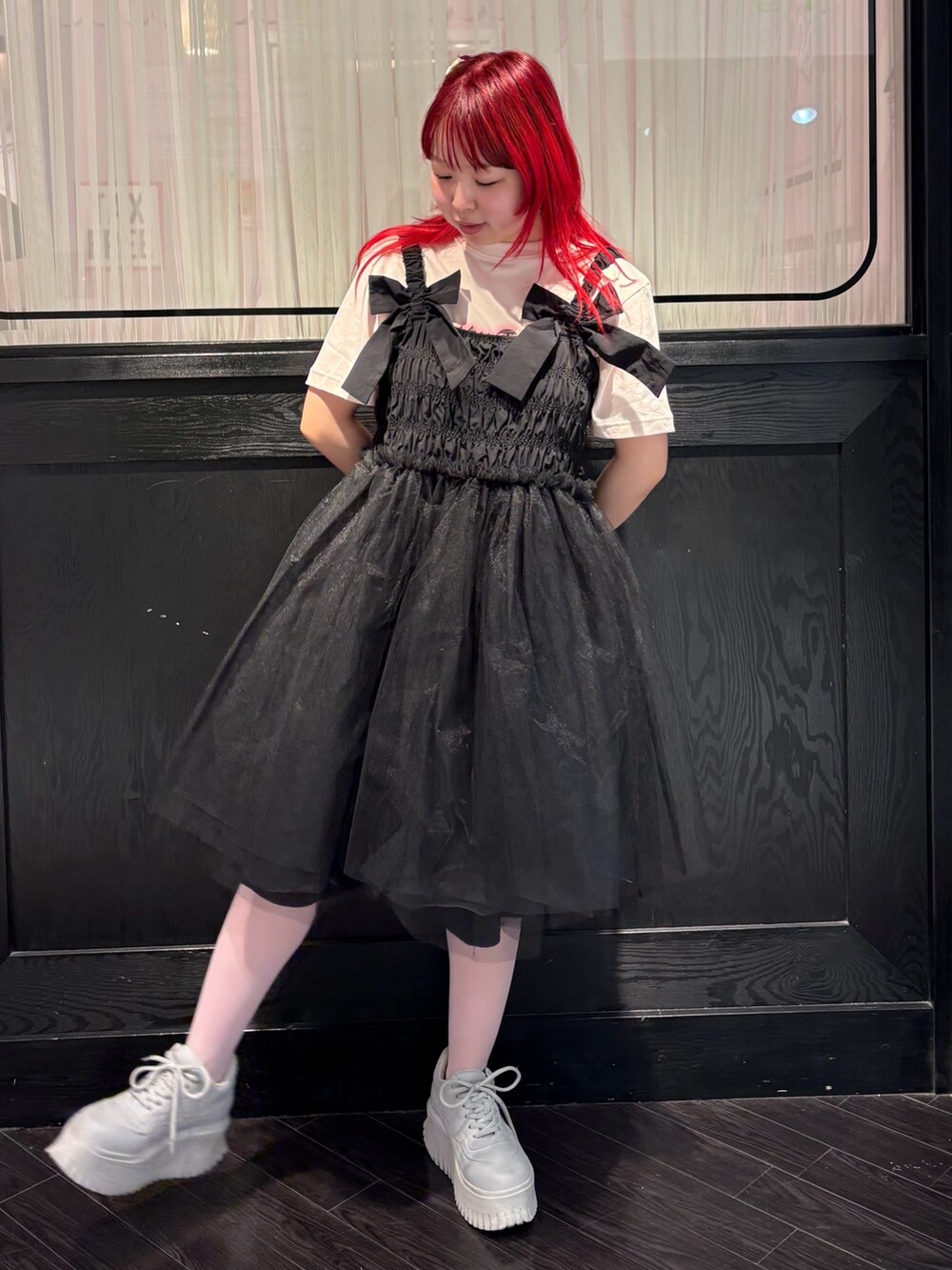 ブラック系のワンピース、ピンク系のTシャツ/カットソーを着用したレディースの春コーディネートの2枚目の写真