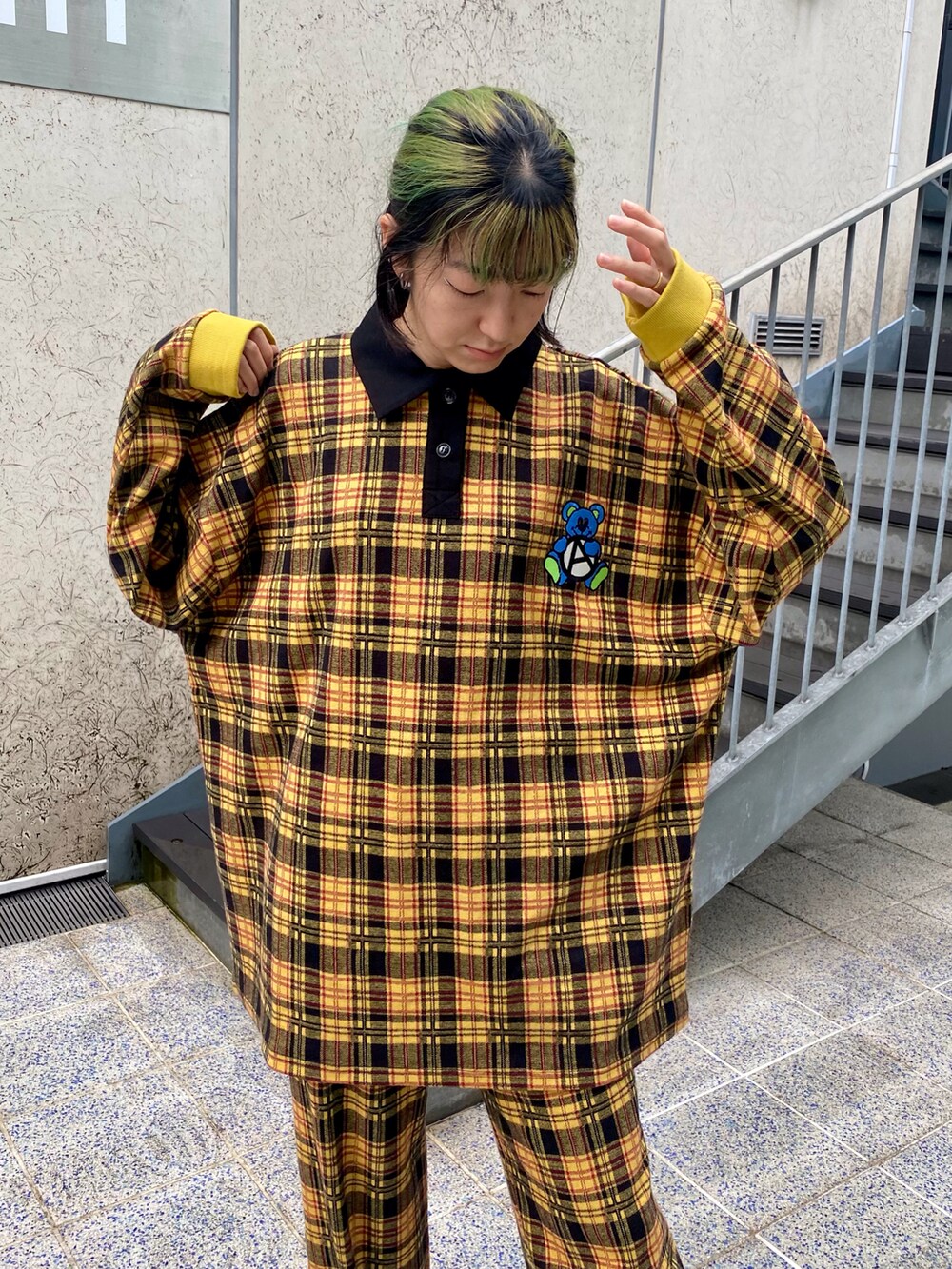 イエロー系のポロシャツ、イエロー系のその他パンツ、ブラック系のスニーカーを着用したレディースの秋コーディネートの5枚目の写真