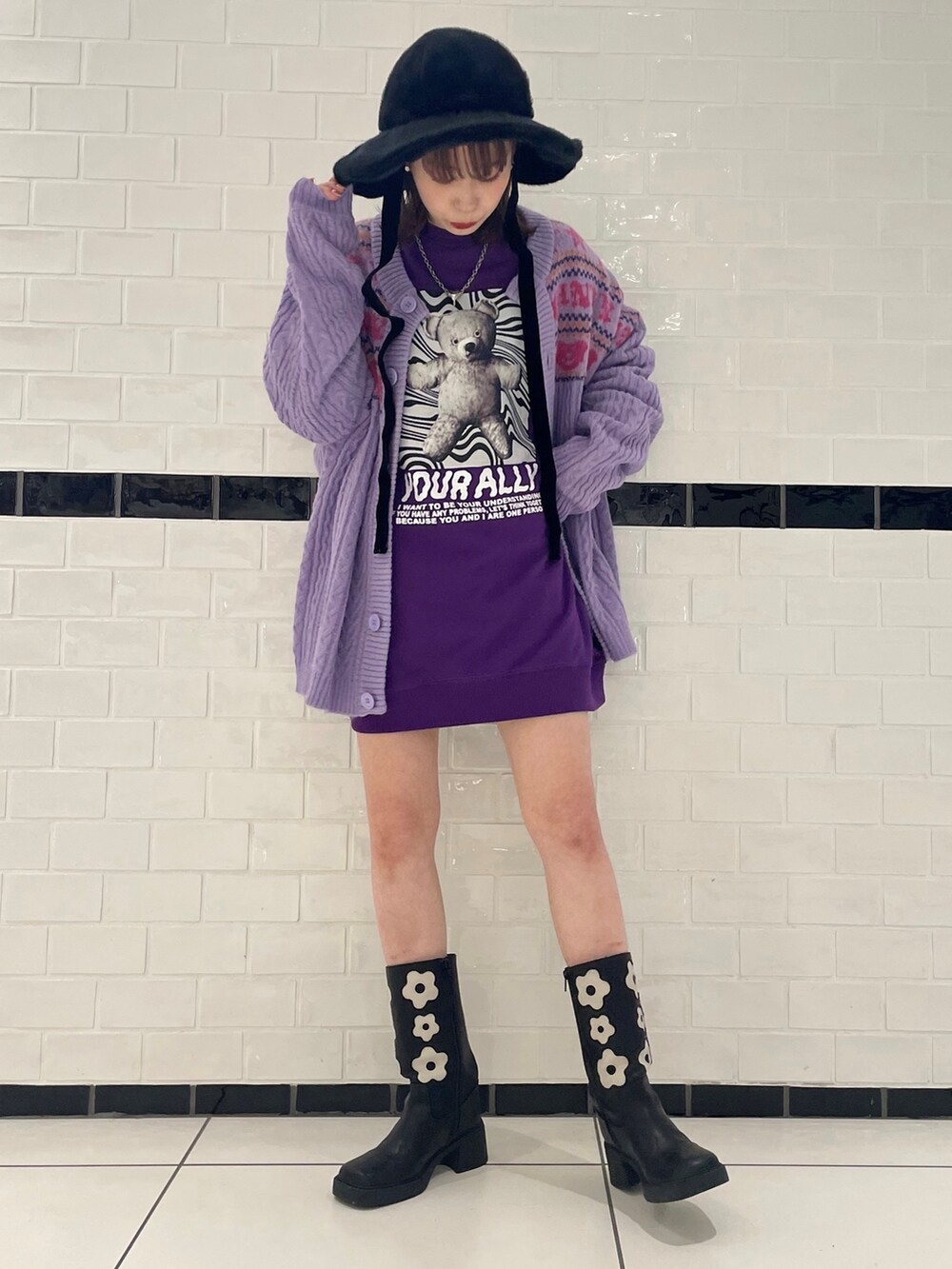 パープル系のスウェット、パープル系のカーディガン/ボレロ、ブラック系のブーツを着用したレディースの冬コーディネートの2枚目の写真