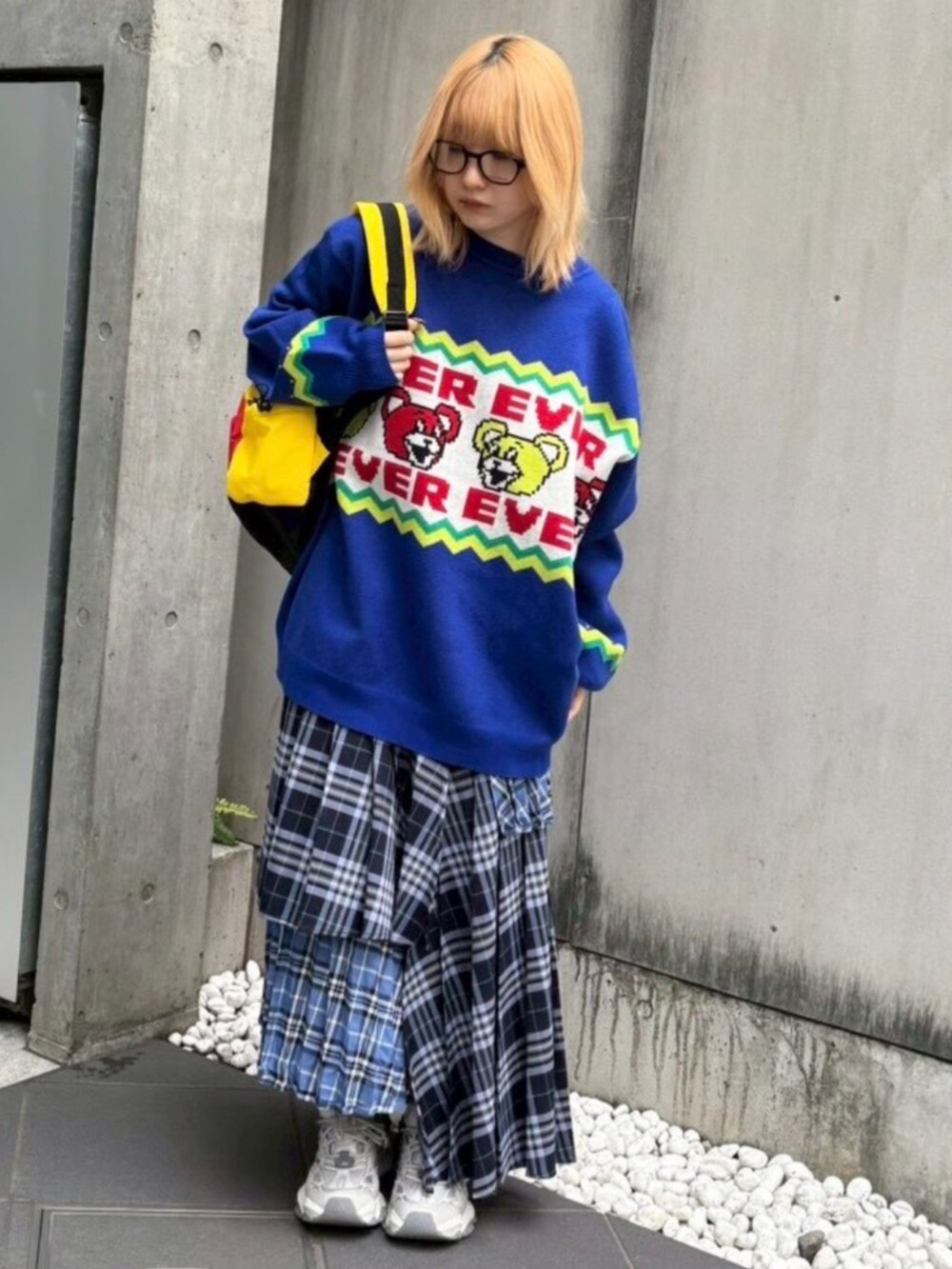 レッド系のバックパック/リュック、ブルー系のスカート、ブルー系のニット/セーターを着用したレディースの秋コーディネートの3枚目の写真