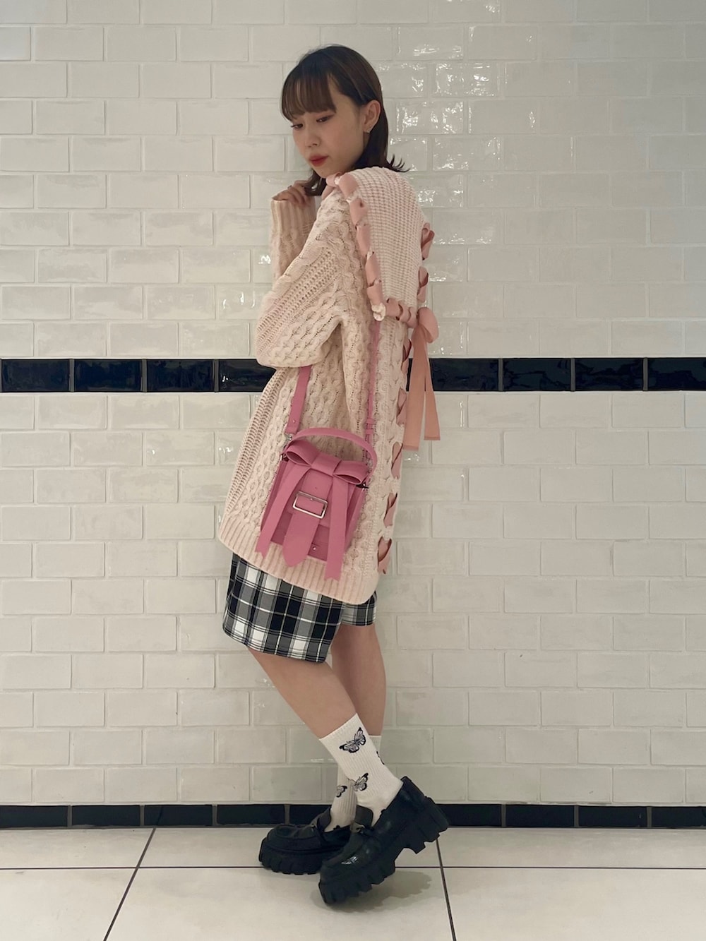 ピンク系のニット/セーター、ブラック系のその他パンツ、ブラック系のハンドバッグを着用したレディースの秋コーディネートの4枚目の写真