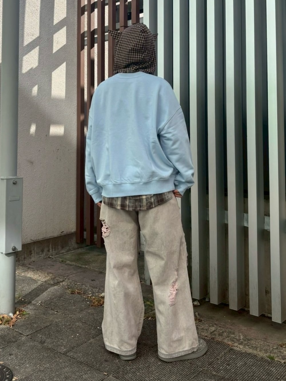 ブラック系のデニムパンツ、ブラウン系のシャツ/ブラウス、ブルー系のスウェットを着用したレディースの冬コーディネートの5枚目の写真