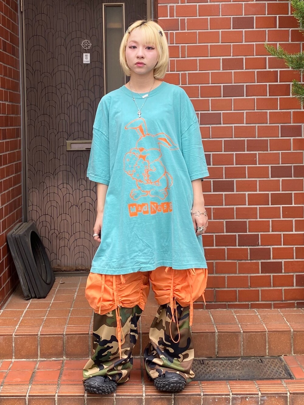 ベージュ系のその他パンツ、オレンジ系のその他パンツ、ホワイト系のTシャツ/カットソーを着用したレディースの春コーディネートの3枚目の写真
