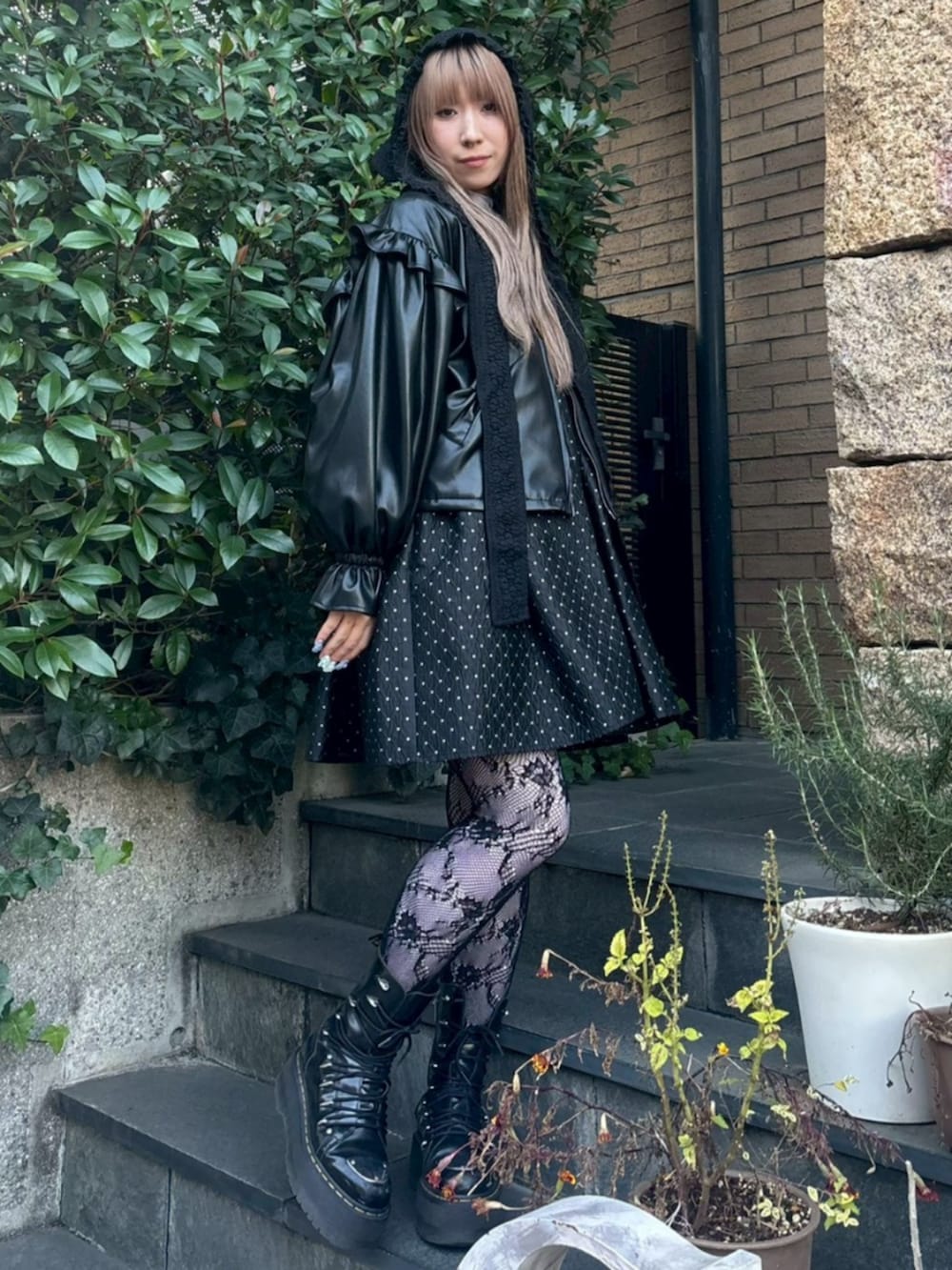 ブラック系のワンピース、ブラック系のライダースジャケット、ホワイト系のTシャツ/カットソーを着用したレディースの冬コーディネートの2枚目の写真