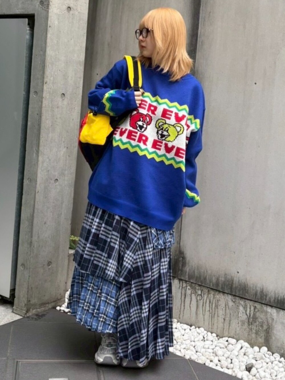 レッド系のバックパック/リュック、ブルー系のスカート、ブルー系のニット/セーターを着用したレディースの秋コーディネートの2枚目の写真