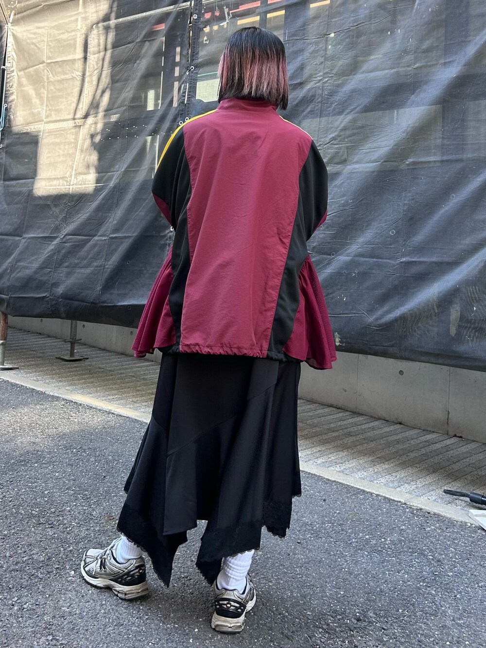 レッド系のブルゾン、ホワイト系のTシャツ/カットソー、ブラック系のワンピースを着用したレディースの冬コーディネートの5枚目の写真
