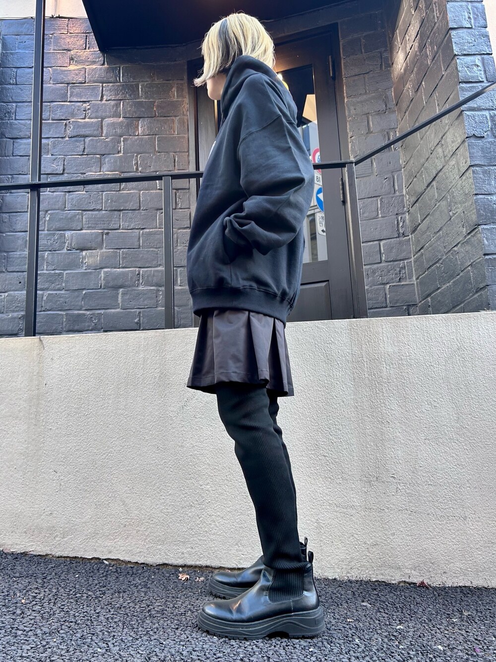 ブラック系のスウェット、ブラック系のスカートを着用したレディースの冬コーディネートの2枚目の写真