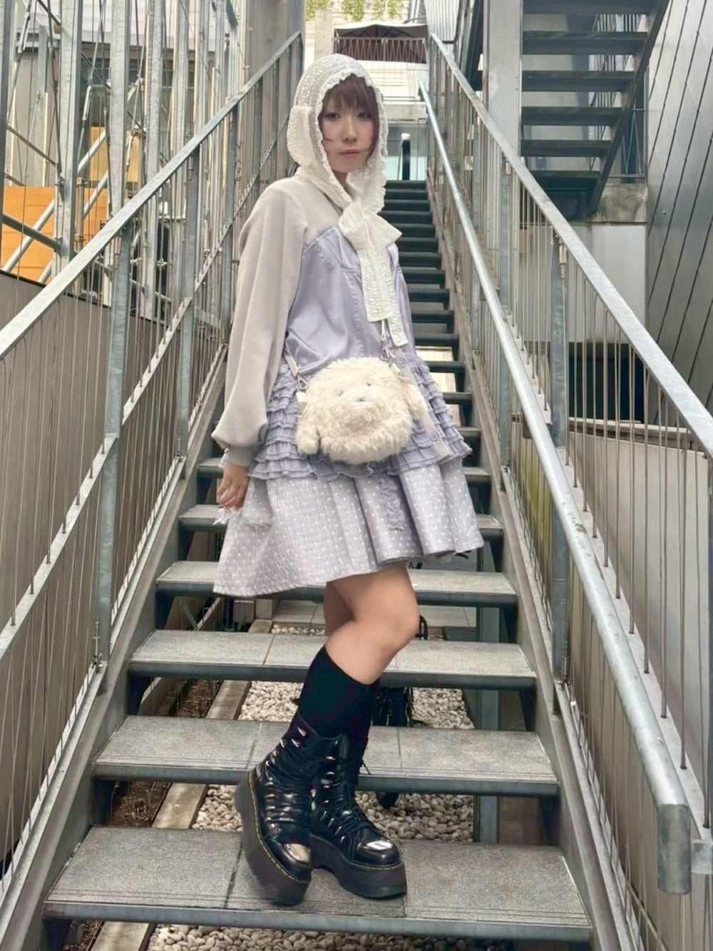 ホワイト系のショルダーバッグ、グレー系のワンピース、グレー系のカーディガン/ボレロを着用したレディースの秋コーディネートの4枚目の写真