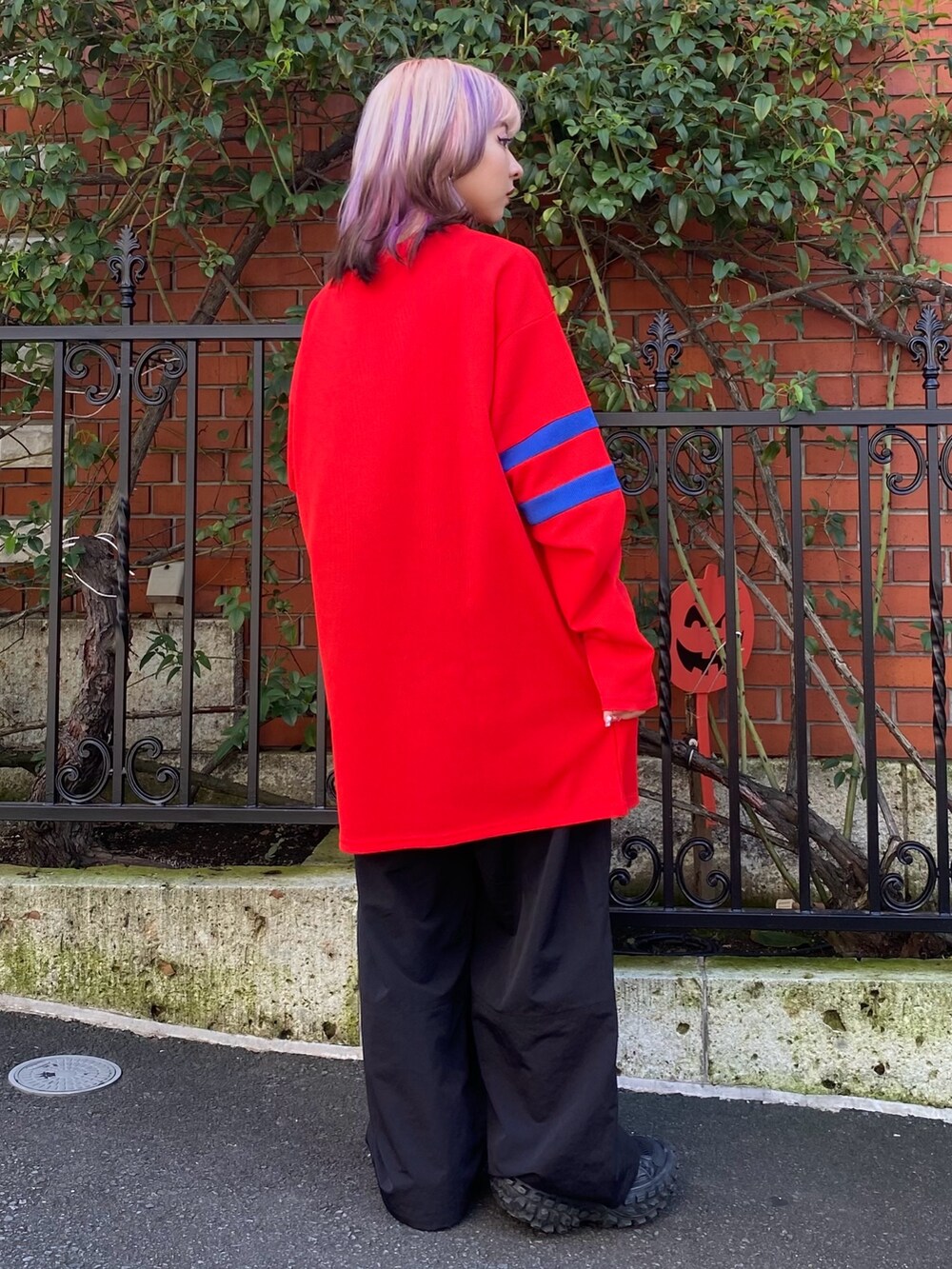 ブラック系のその他パンツ、レッド系のTシャツ/カットソーを着用したレディースの秋コーディネートの4枚目の写真