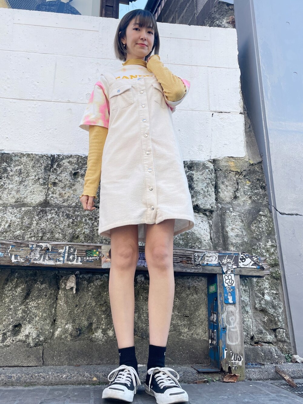 ホワイト系のその他アウター、ホワイト系のジャンパースカート、イエロー系のTシャツ/カットソーを着用したレディースの冬コーディネートの2枚目の写真