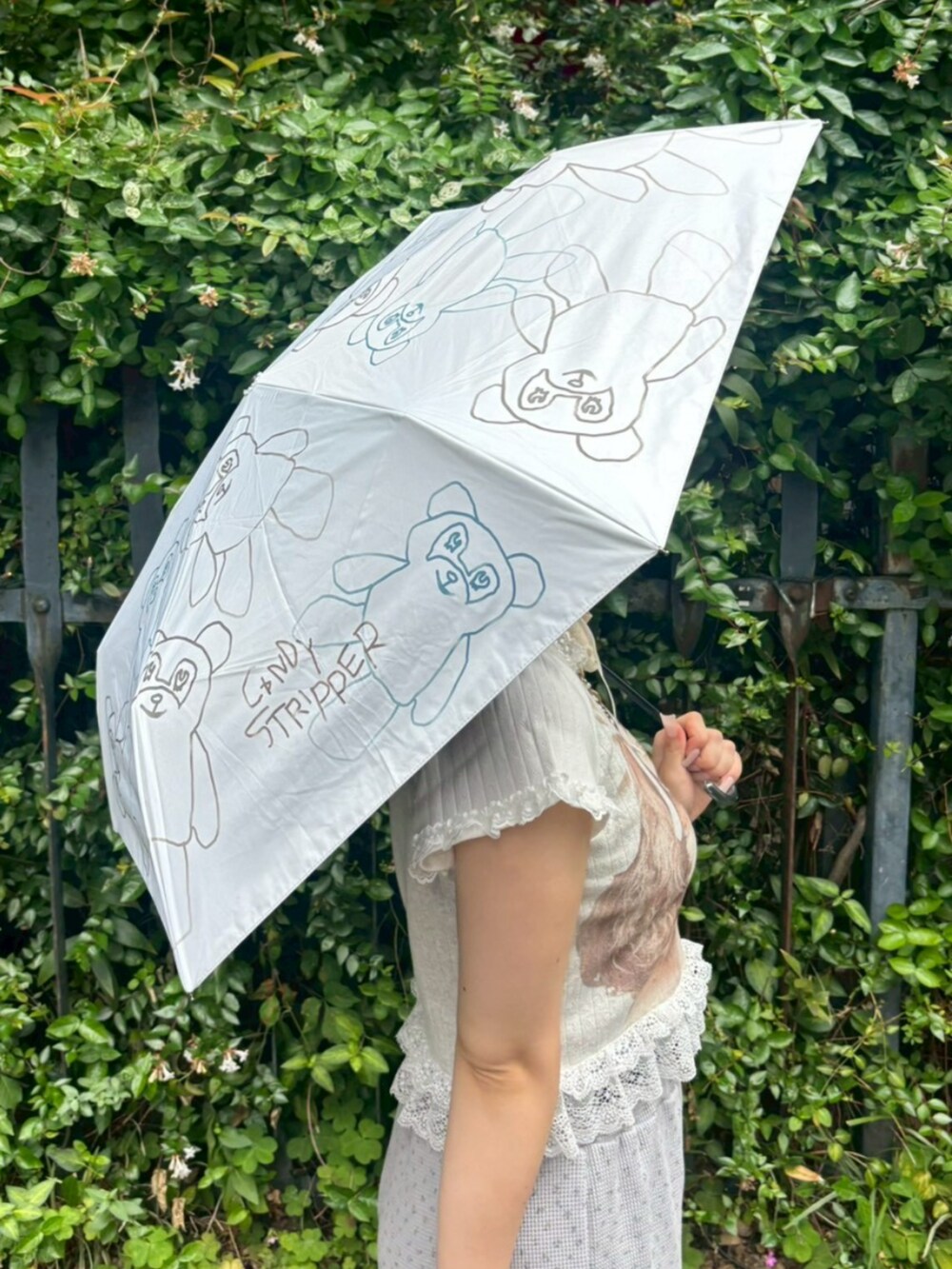 グレー系のその他パンツ、ホワイト系のTシャツ/カットソー、ホワイト系の折りたたみ傘を着用したレディースの夏コーディネートの5枚目の写真