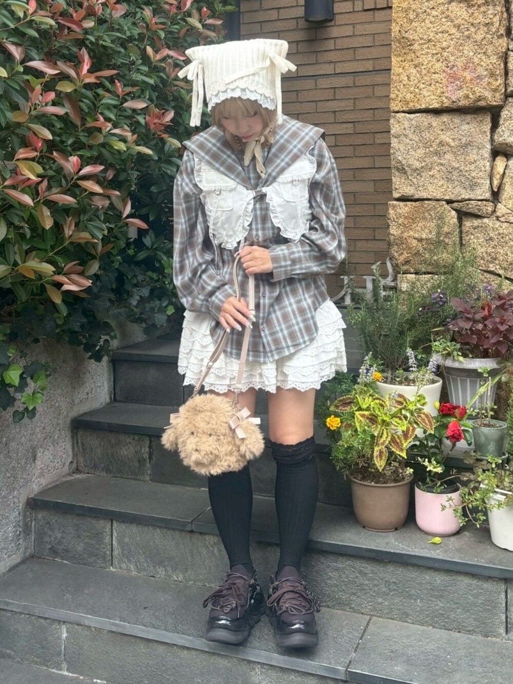 ブラウン系のシャツ/ブラウス、ホワイト系のベスト、ホワイト系のスカートを着用したレディースの秋コーディネートの5枚目の写真