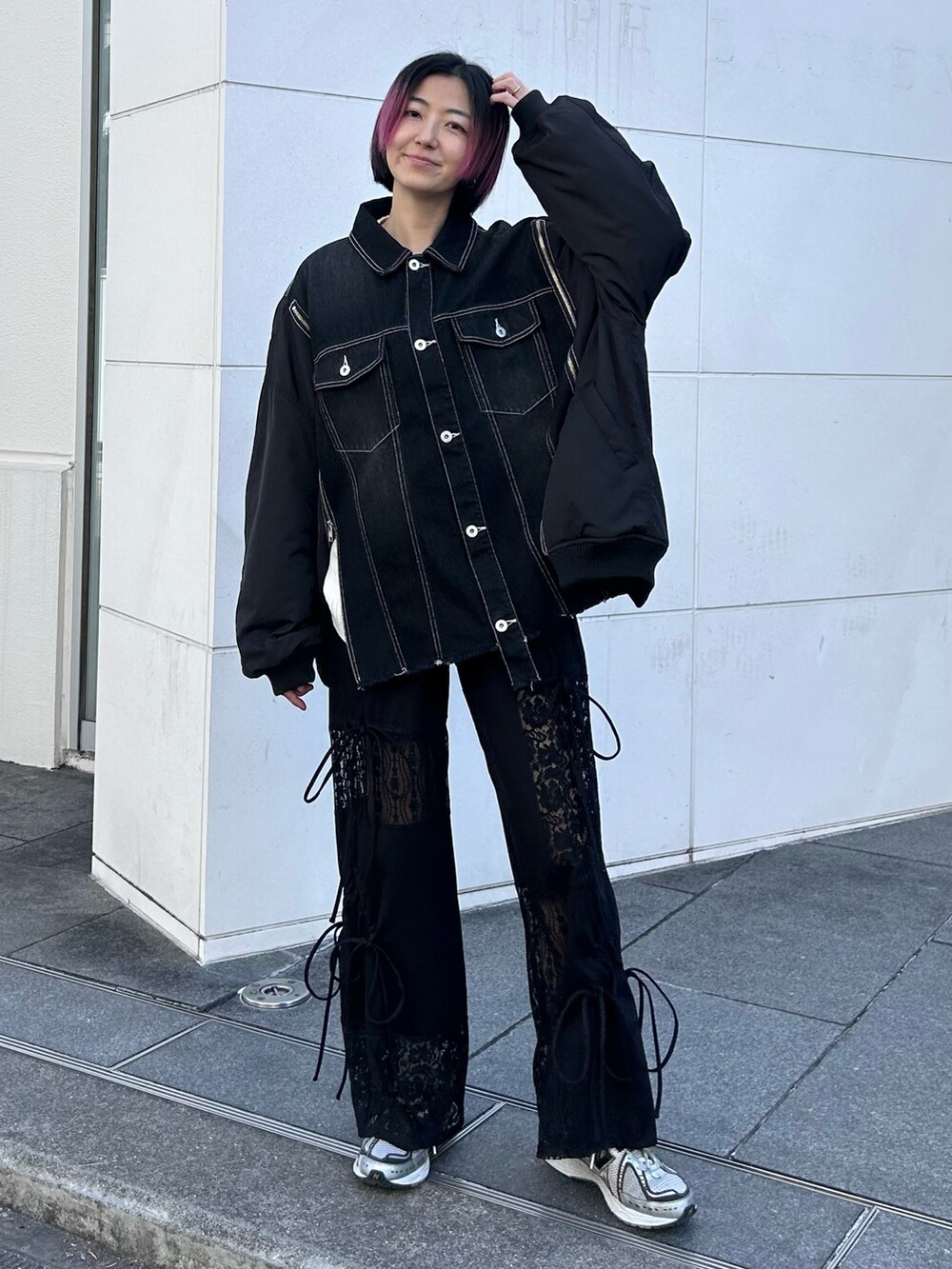 ブラック系のデニムジャケット、ホワイト系のニット/セーター、ブラック系のその他パンツを着用したレディースの冬コーディネートの3枚目の写真