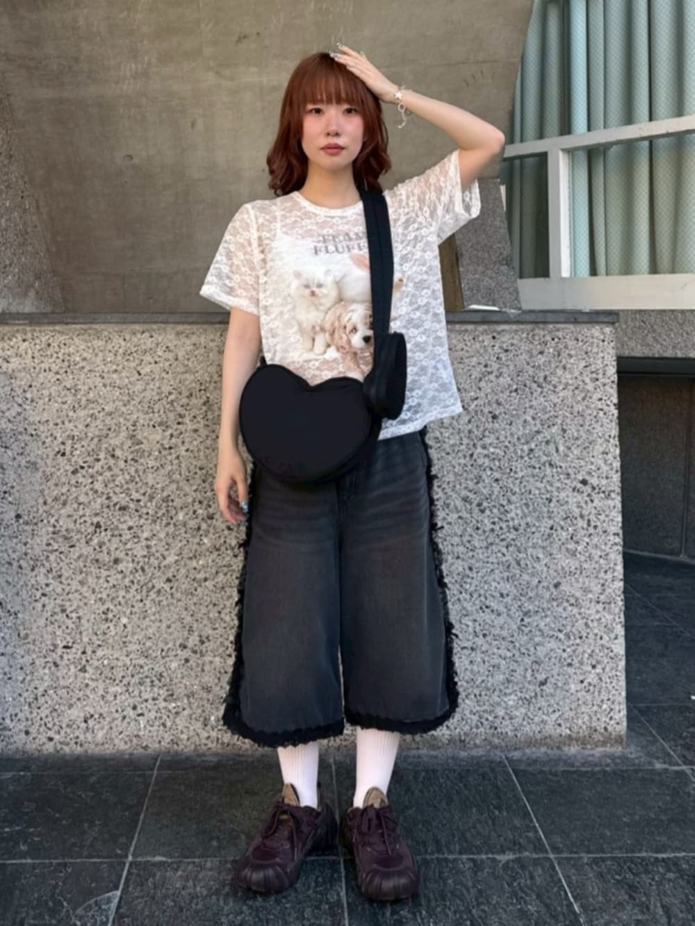 ブラック系のデニムパンツ、ブラック系のショルダーバッグ、ホワイト系のTシャツ/カットソーを着用したレディースの夏コーディネートの2枚目の写真