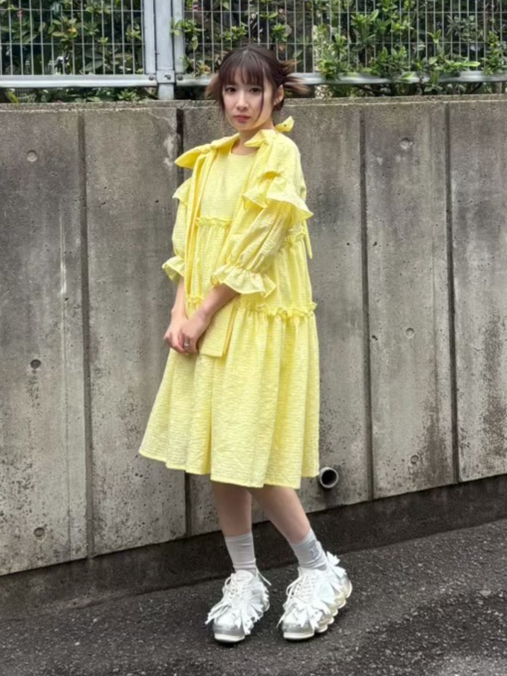 イエロー系のワンピースを着用したレディースの夏コーディネートの2枚目の写真