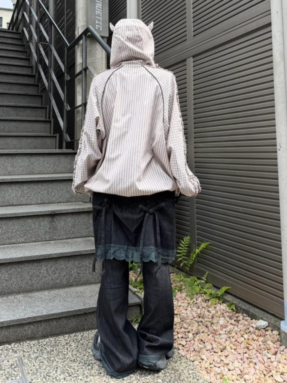 ブラック系のデニムパンツ、ブラック系のTシャツ/カットソー、ベージュ系のブルゾンを着用したレディースの秋コーディネートの3枚目の写真