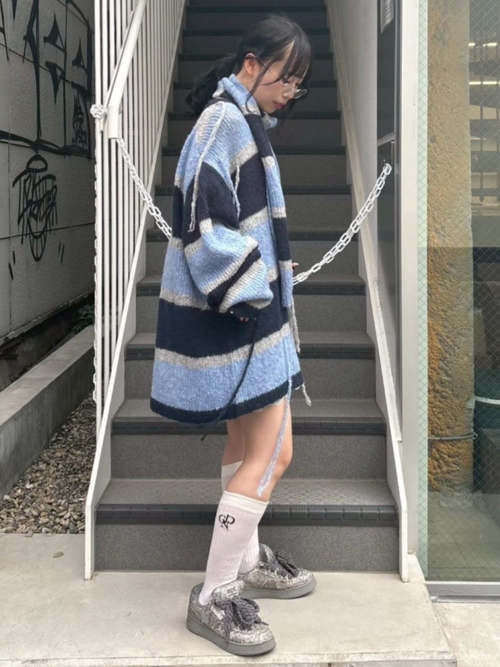 ブルー系のワンピース、グレー系のニット/セーターを着用したレディースの秋コーディネートの4枚目の写真