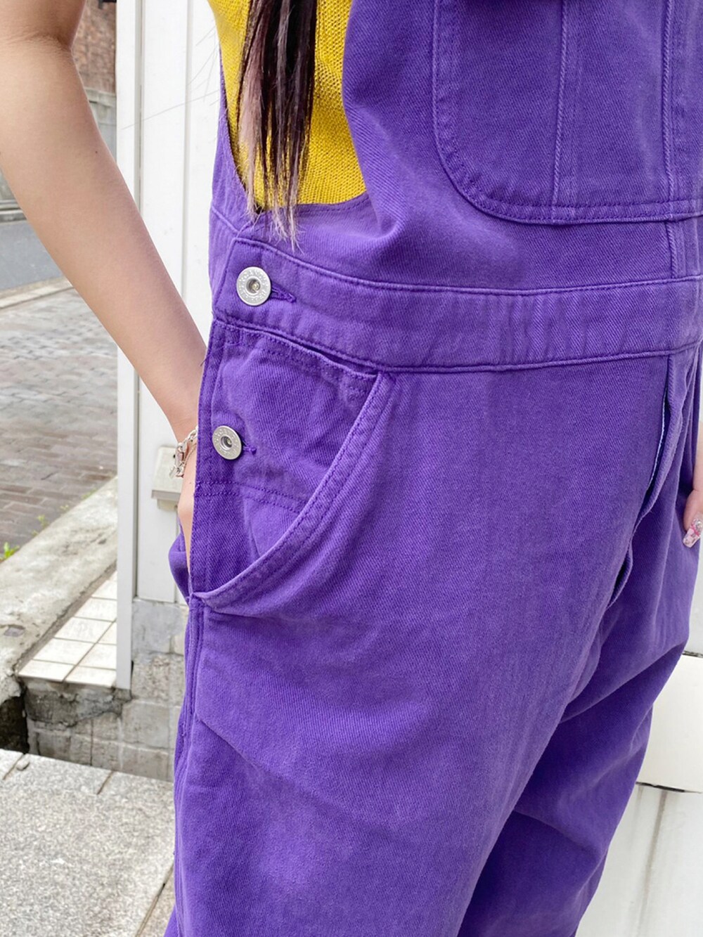 パープル系のサロペット/オーバーオール、イエロー系のカーディガン/ボレロ、ブラック系のハットを着用したレディースの春コーディネートの4枚目の写真