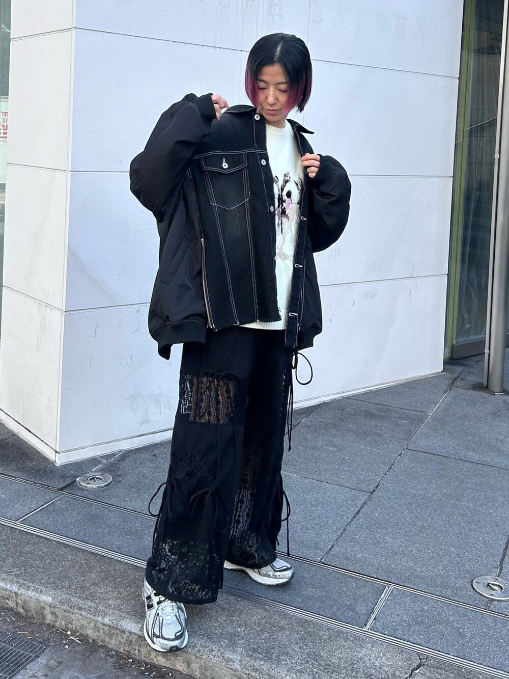 ブラック系のデニムジャケット、ホワイト系のニット/セーター、ブラック系のその他パンツを着用したレディースの冬コーディネートの2枚目の写真