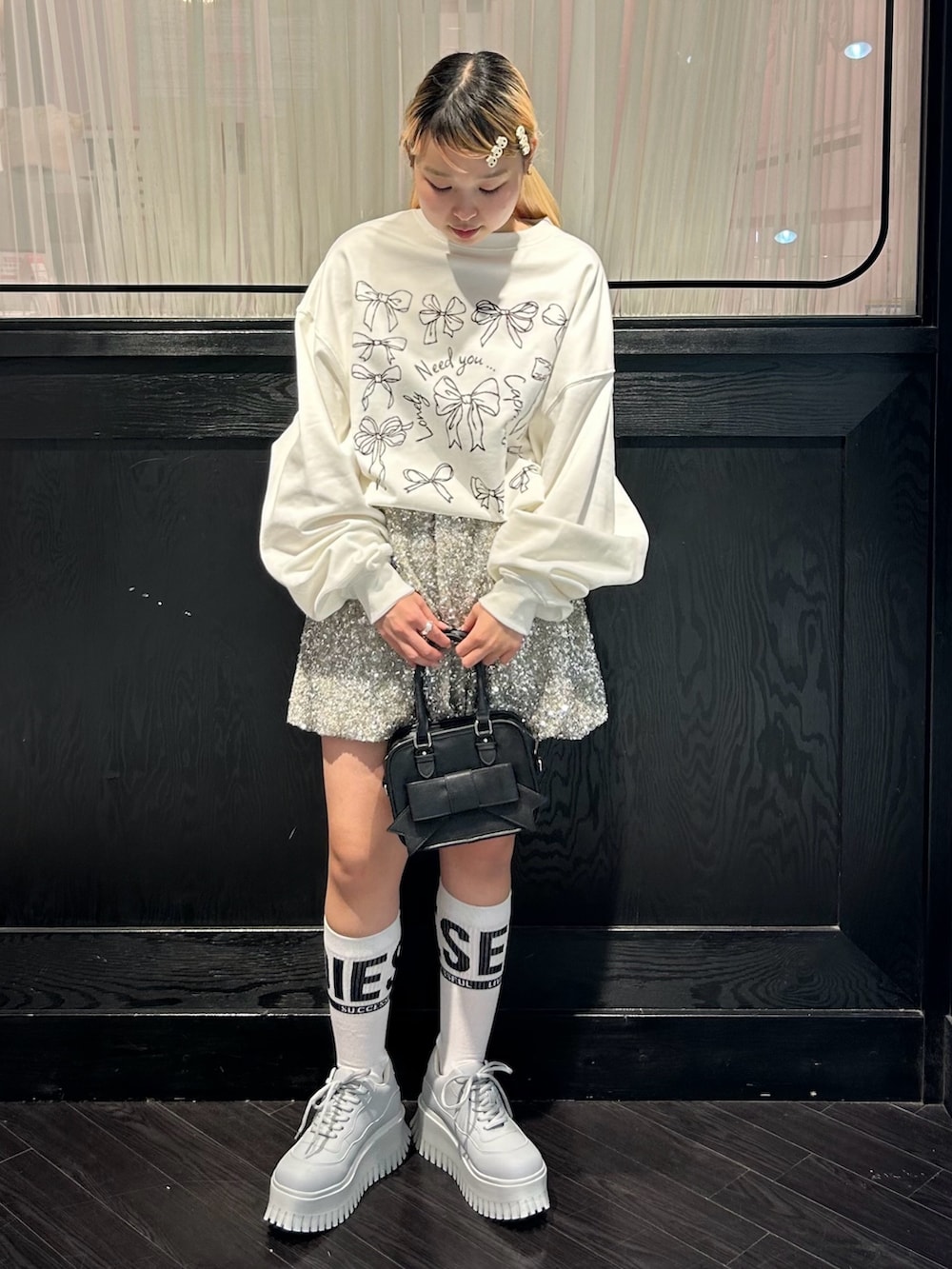 ホワイト系のスウェット、シルバー系のその他パンツ、ブラック系のショルダーバッグを着用したレディースの秋コーディネートの2枚目の写真