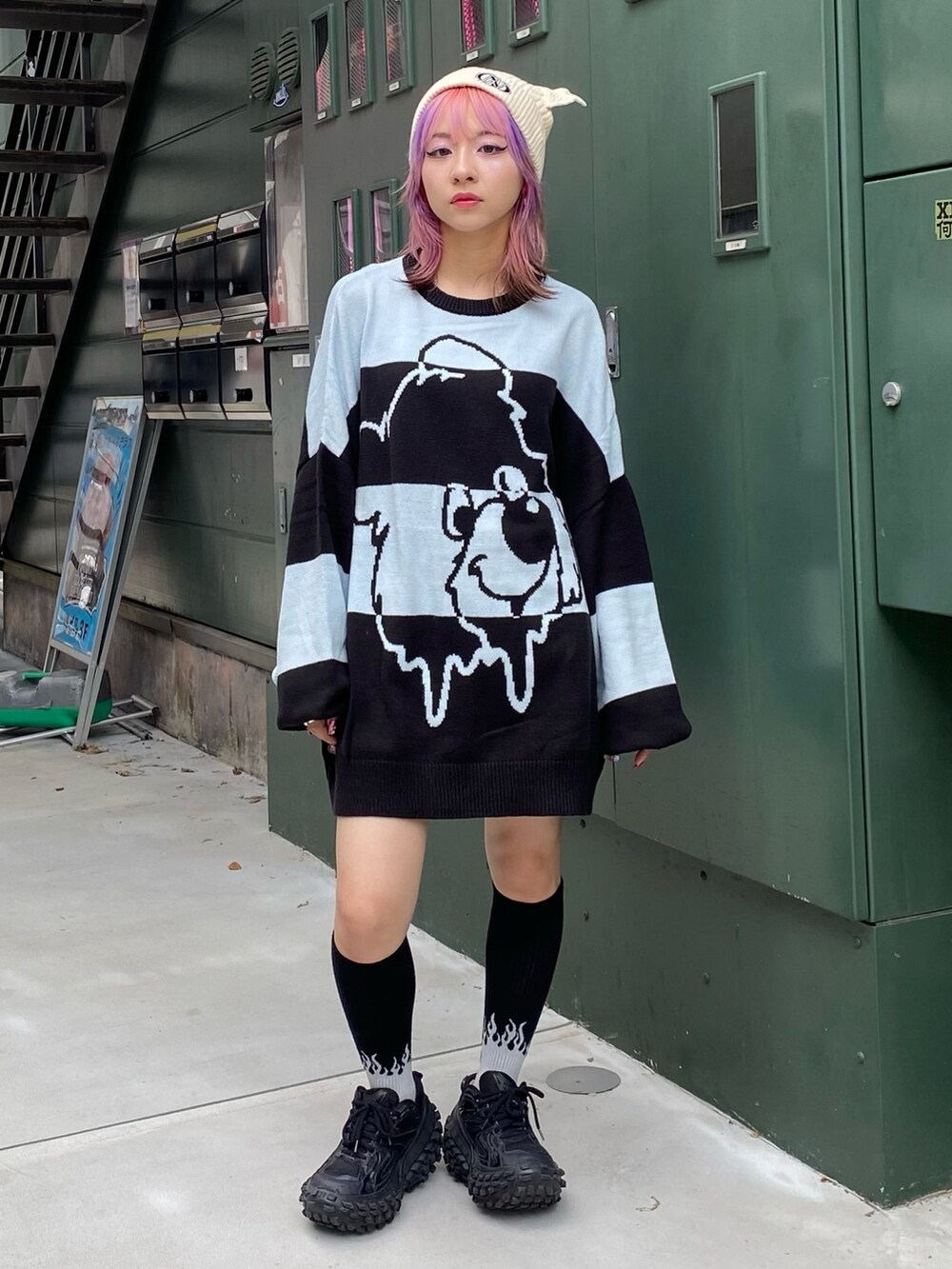 ブラック系のスタジャン、ブラック系のニット/セーター、ホワイト系のニットキャップ/ビーニーを着用したレディースの秋コーディネートの4枚目の写真