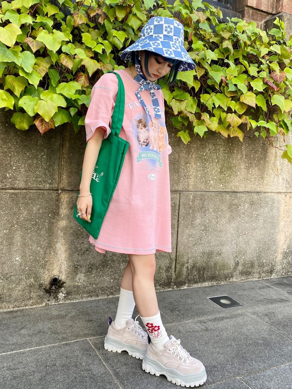 ピンク系のTシャツ/カットソー、グリーン系のトートバッグ、ブルー系のハットを着用したレディースの春コーディネートの2枚目の写真