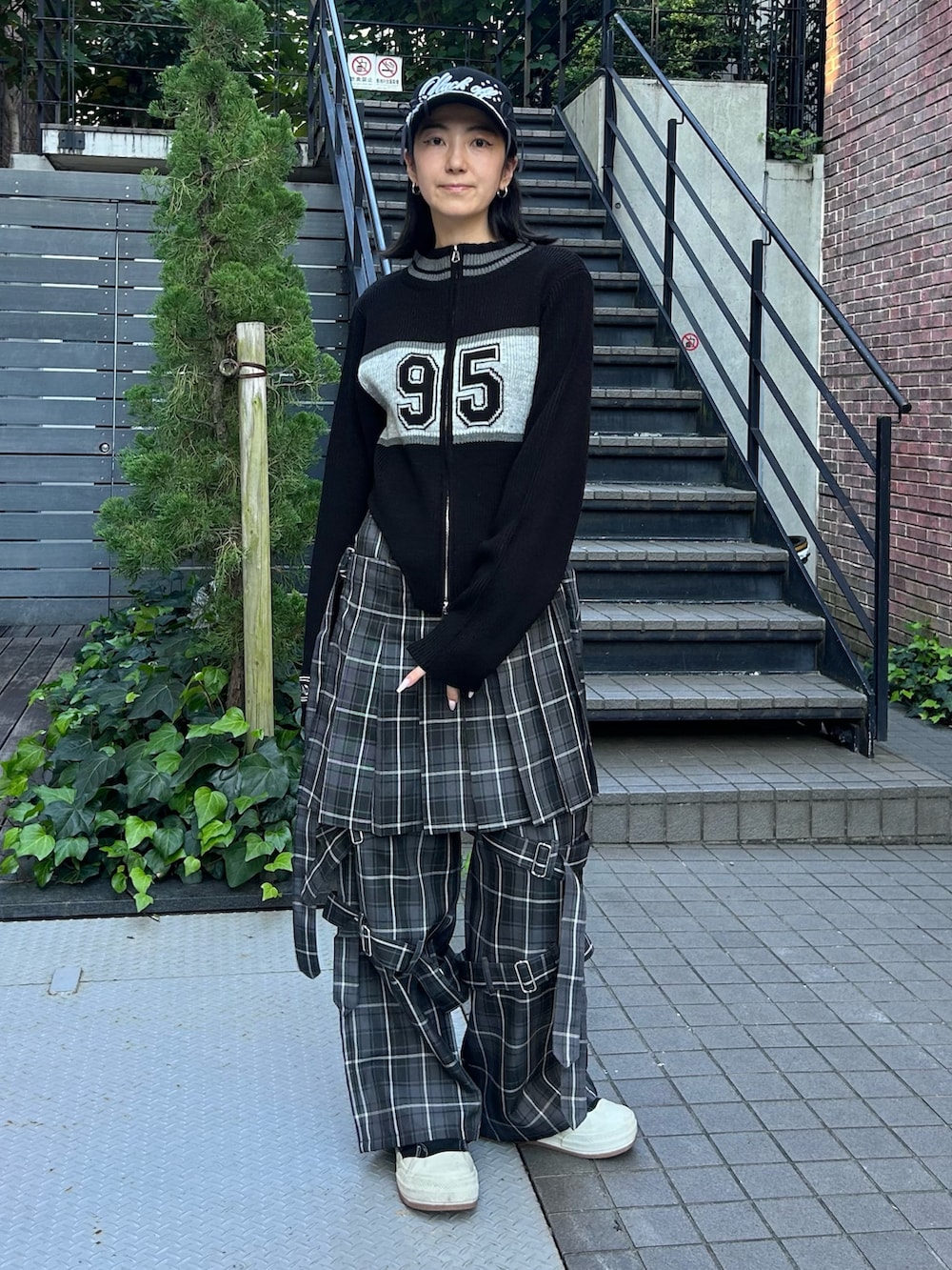 グレー系のその他パンツ、ブラック系のニット/セーター、ブラック系のキャップを着用したレディースの秋コーディネートの2枚目の写真