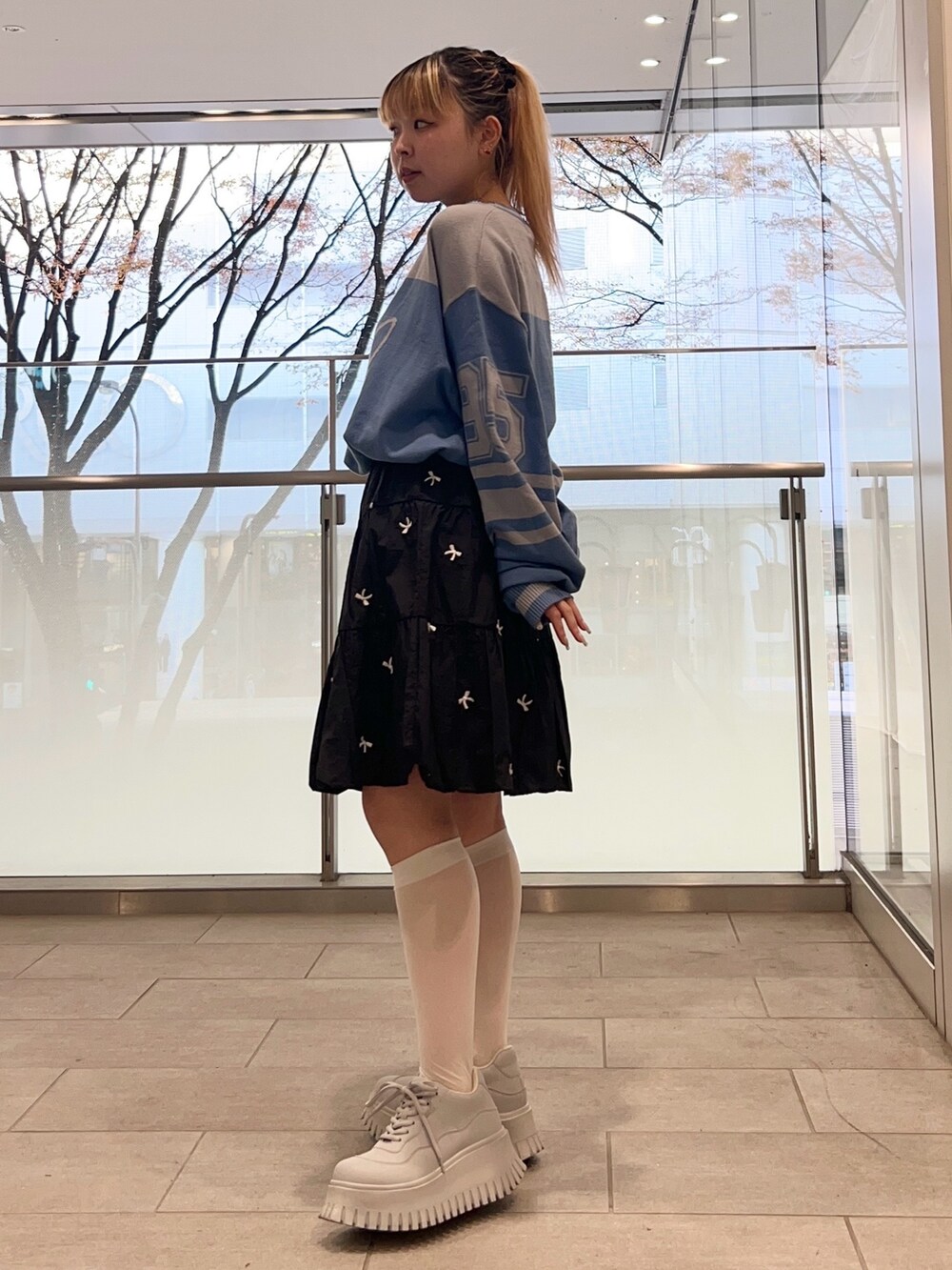 ブラック系のスカート、ブルー系のニット/セーター、ブラック系のダウンジャケット/コートを着用したレディースの冬コーディネートの5枚目の写真