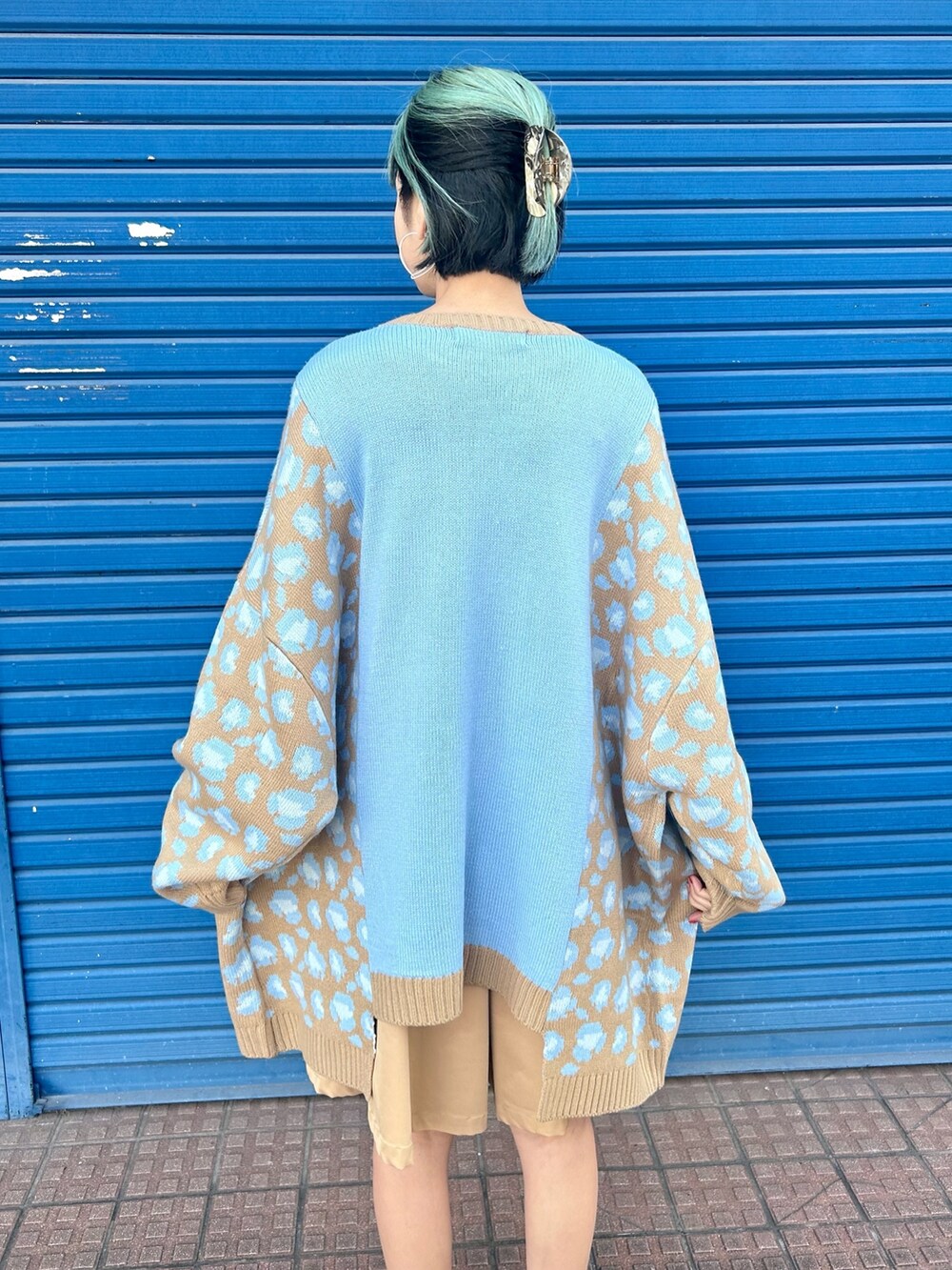 ベージュ系のスカート、ブルー系のニット/セーターを着用したレディースの冬コーディネートの5枚目の写真