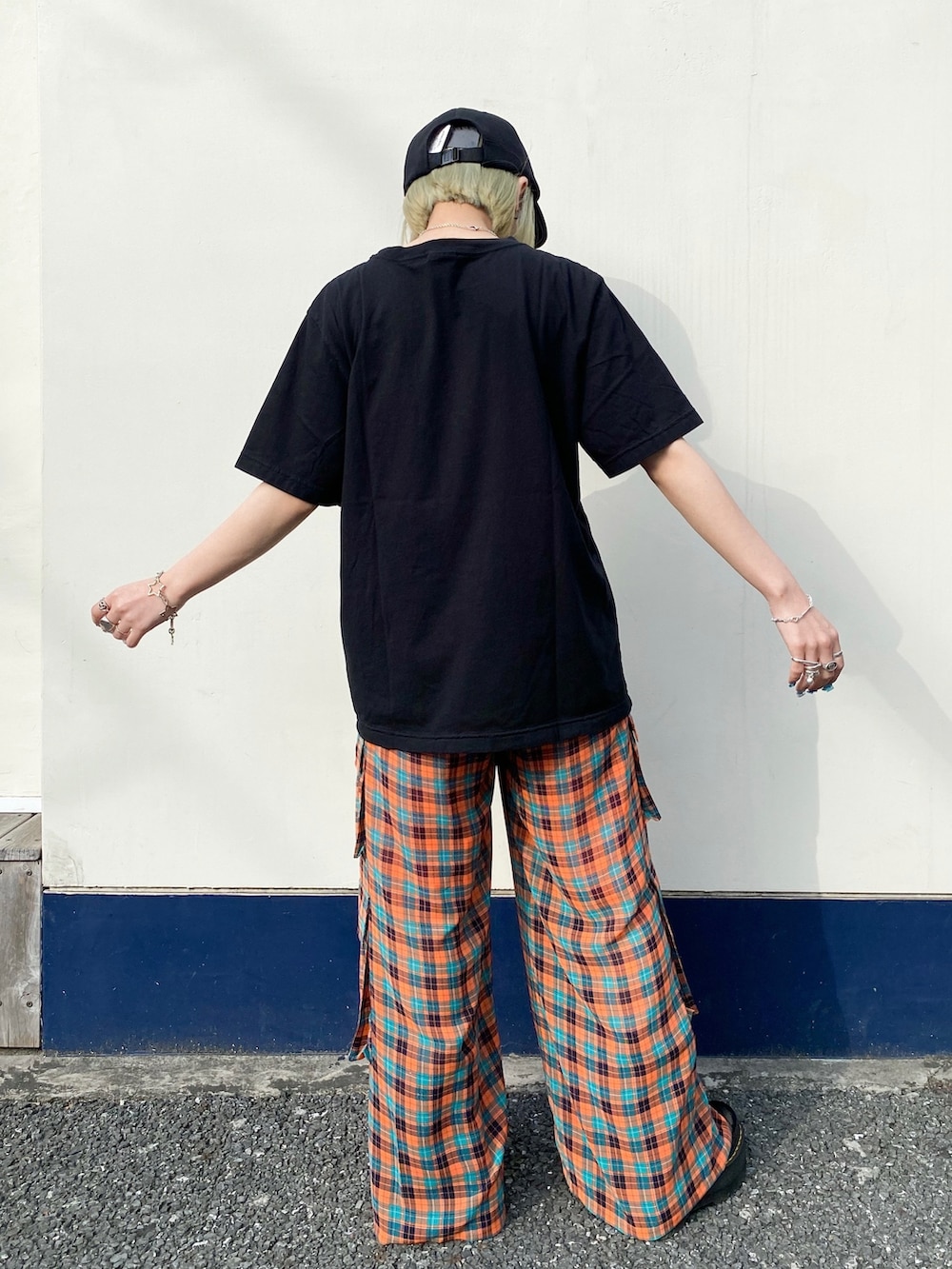 ブラック系のTシャツ/カットソー、オレンジ系のその他パンツ、ブラック系のシューズを着用したレディースの春コーディネートの3枚目の写真