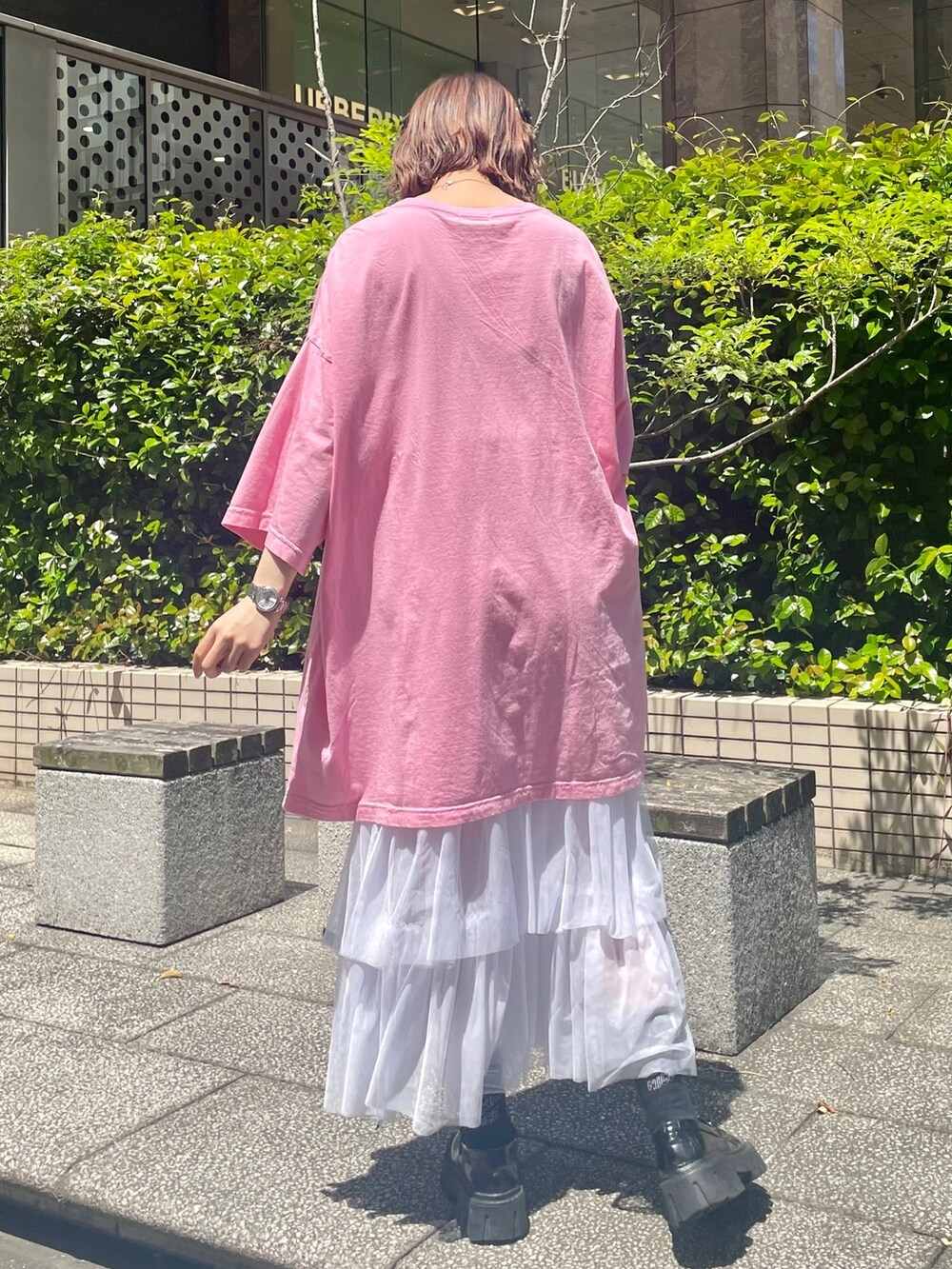 ブラック系のローファー、ホワイト系のワンピース、ピンク系のTシャツ/カットソーを着用したレディースの春コーディネートの3枚目の写真