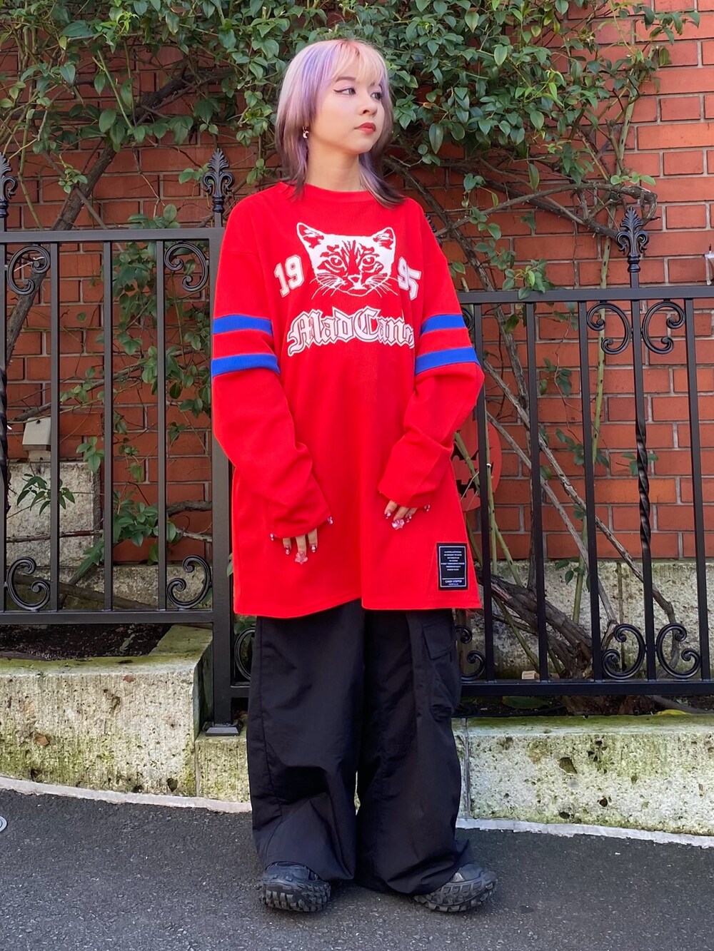 ブラック系のその他パンツ、レッド系のTシャツ/カットソーを着用したレディースの秋コーディネートの2枚目の写真