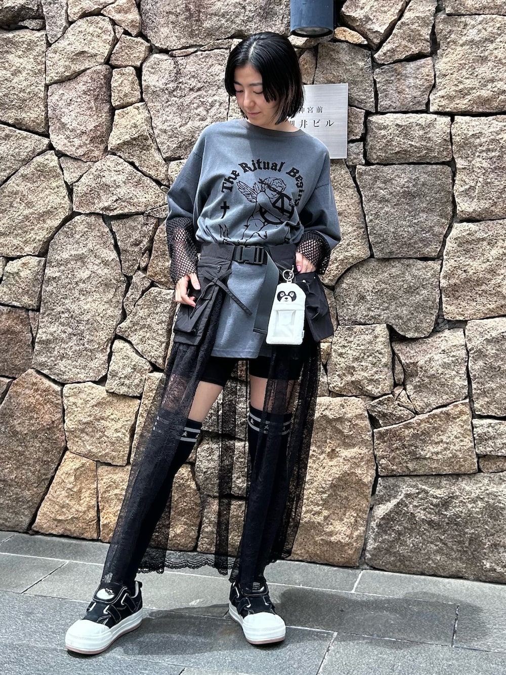 グレー系のTシャツ/カットソー、ブラック系のスカート、ブラック系のソックス/靴下を着用したレディースの春コーディネートの4枚目の写真