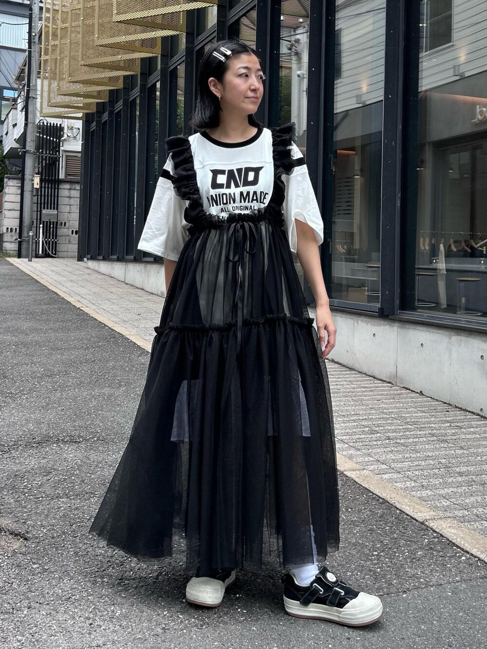 ブラック系のスカート、ホワイト系のワンピースを着用したレディースの秋コーディネートの2枚目の写真