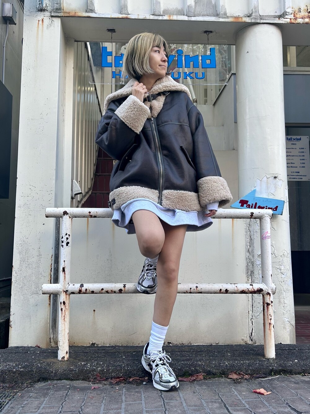 グレー系のスウェット、ブラック系のその他アウターを着用したレディースの冬コーディネートの2枚目の写真