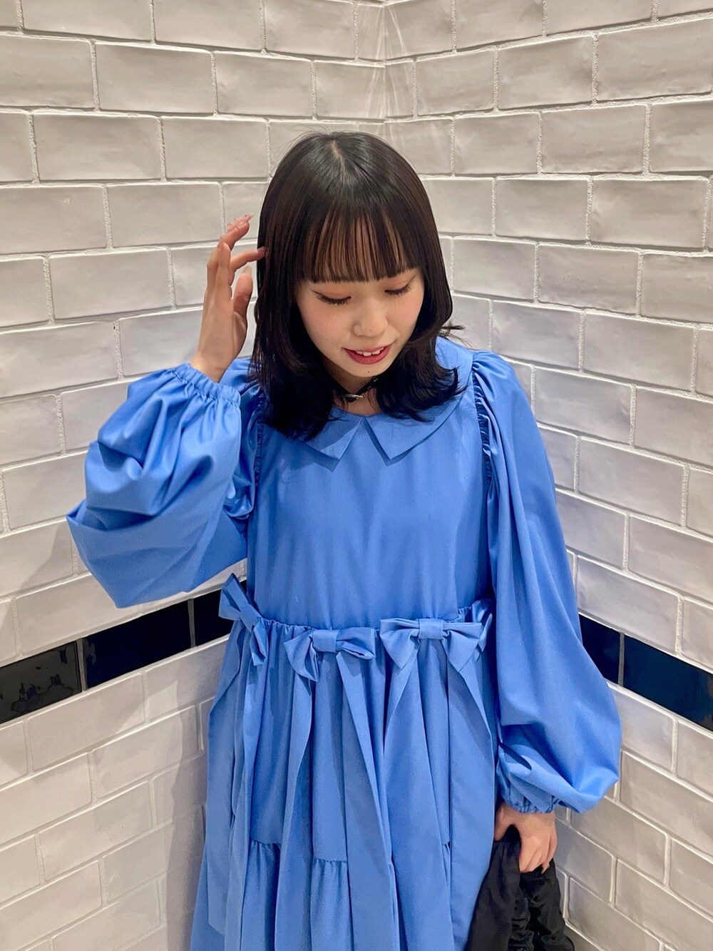 ブラック系のハンドバッグ、ブルー系のワンピース、ホワイト系のソックス/靴下を着用したレディースの冬コーディネートの5枚目の写真