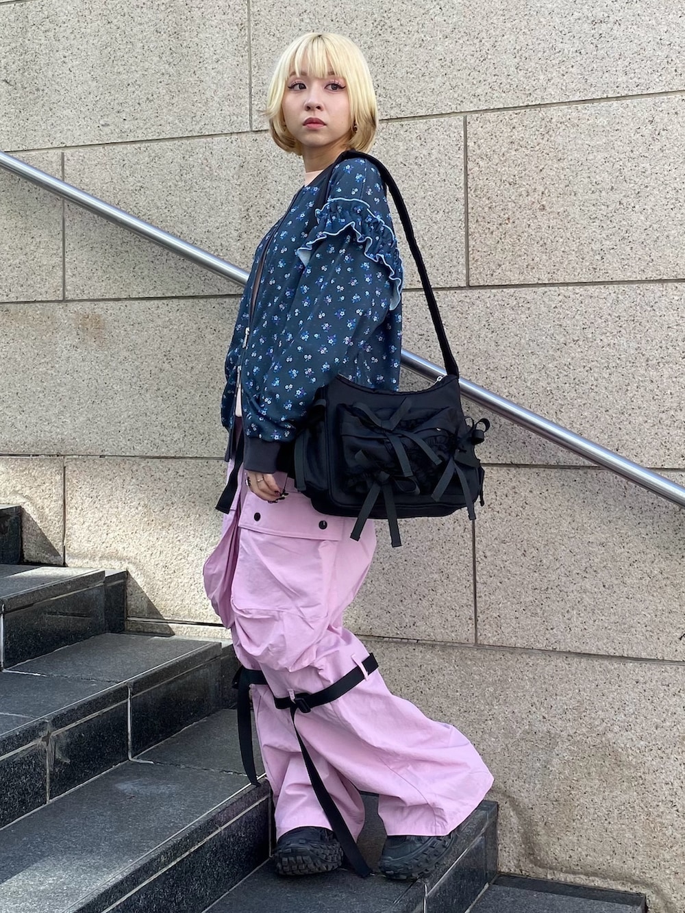 ブラック系のブルゾン、ピンク系のTシャツ/カットソー、ピンク系のカーゴパンツを着用したレディースの春コーディネートの4枚目の写真