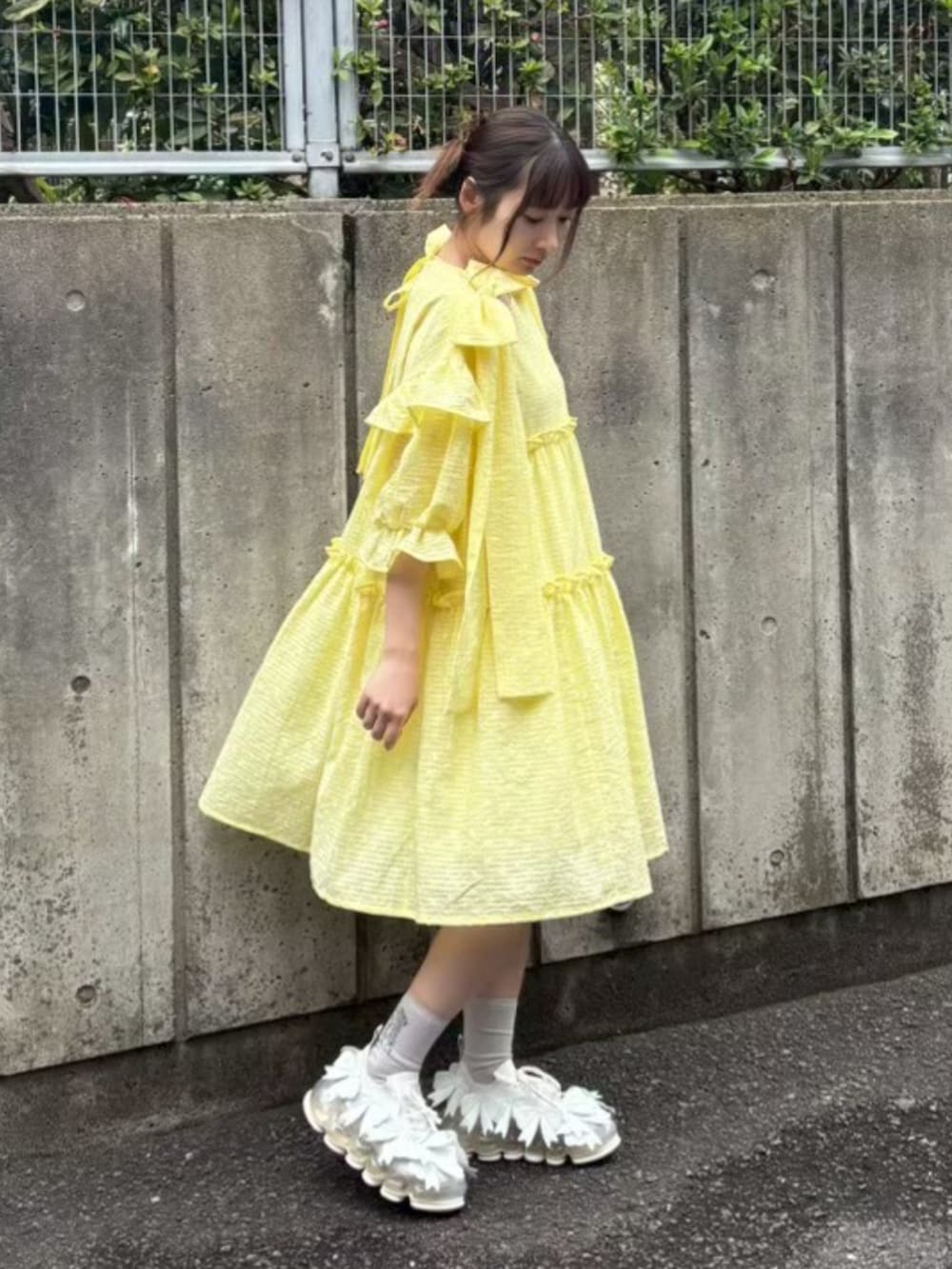 イエロー系のワンピースを着用したレディースの夏コーディネートの3枚目の写真