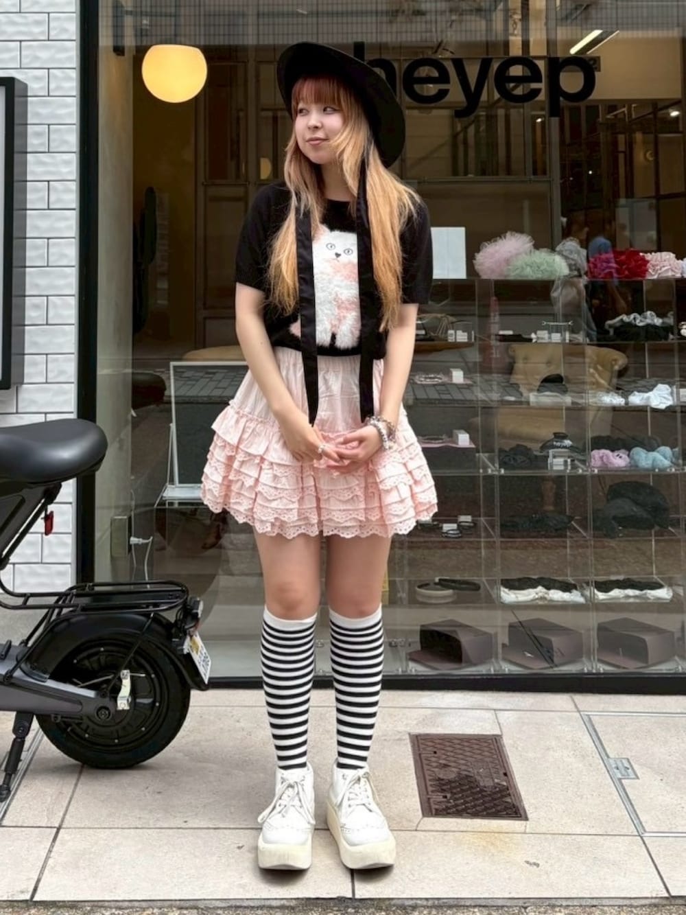 ピンク系のスカート、ブラック系のニット/セーター、ブラック系のハットを着用したレディースの夏コーディネートの3枚目の写真