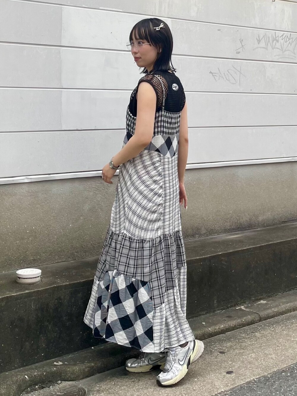 ブラック系のワンピース、ブラック系のワンピース、シルバー系のシューズを着用したレディースの夏コーディネートの3枚目の写真