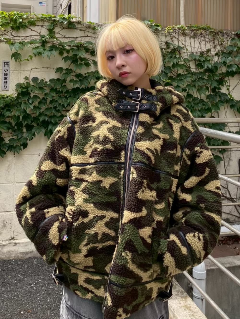 ブラック系のデニムパンツ、グリーン系のダウンジャケット/コート、レッド系のニット/セーターを着用したレディースの冬コーディネートの3枚目の写真